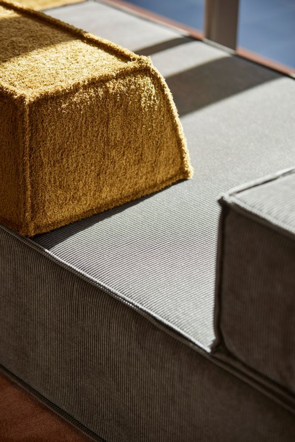 Detailaufnahme des Trio Sofa Eckmoduls in Grau und Senfgelb, modernes modulares Wohnzimmermöbel.