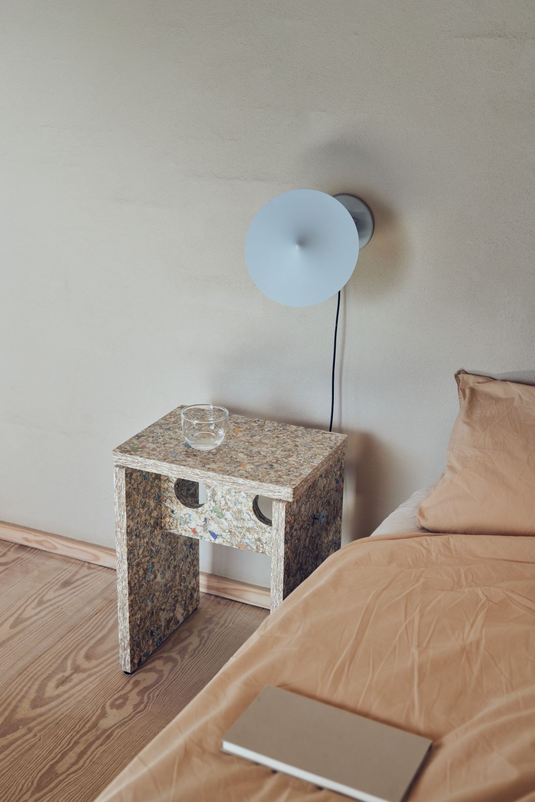 Remake Hocker als Nachttisch im Schlafzimmer mit Lampe, Wasserglas und Buch auf dem Bett.