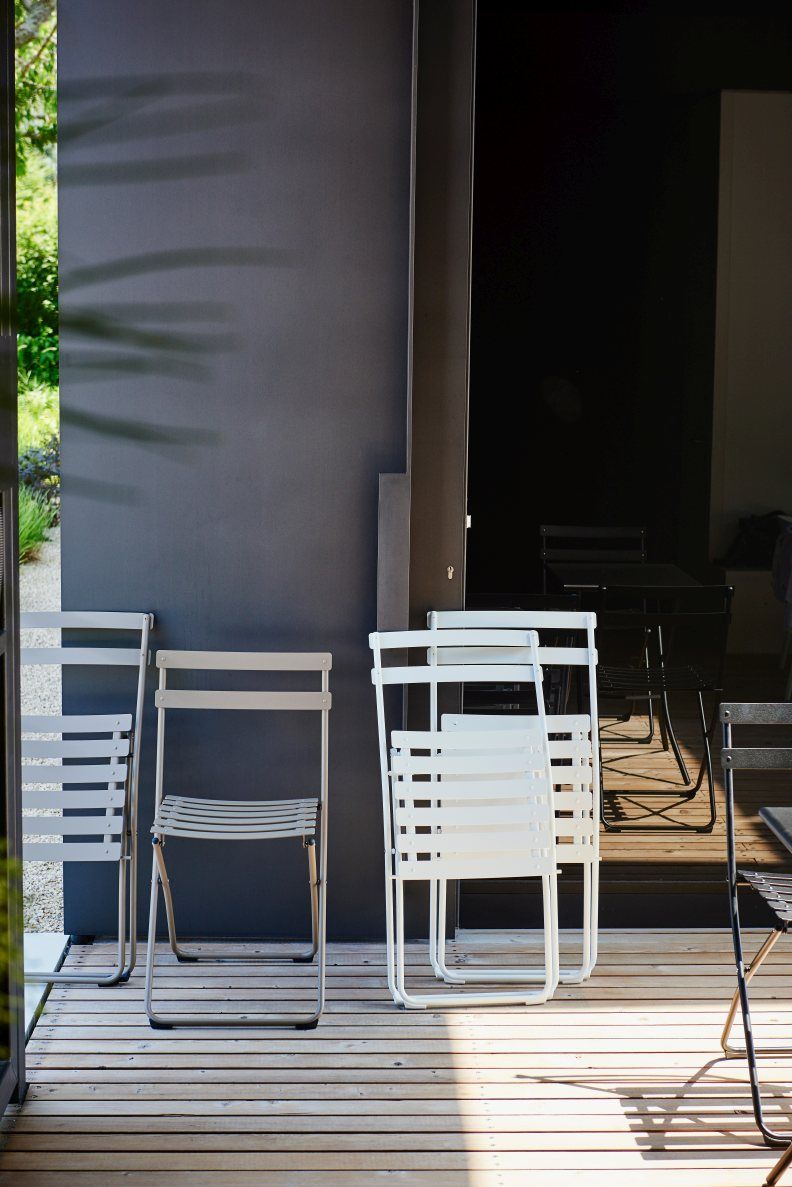 Fiam Spring Klappstühle in Taupe und Weiß auf Holzterrasse, ideal für den Garten. Outdoor Möbel.