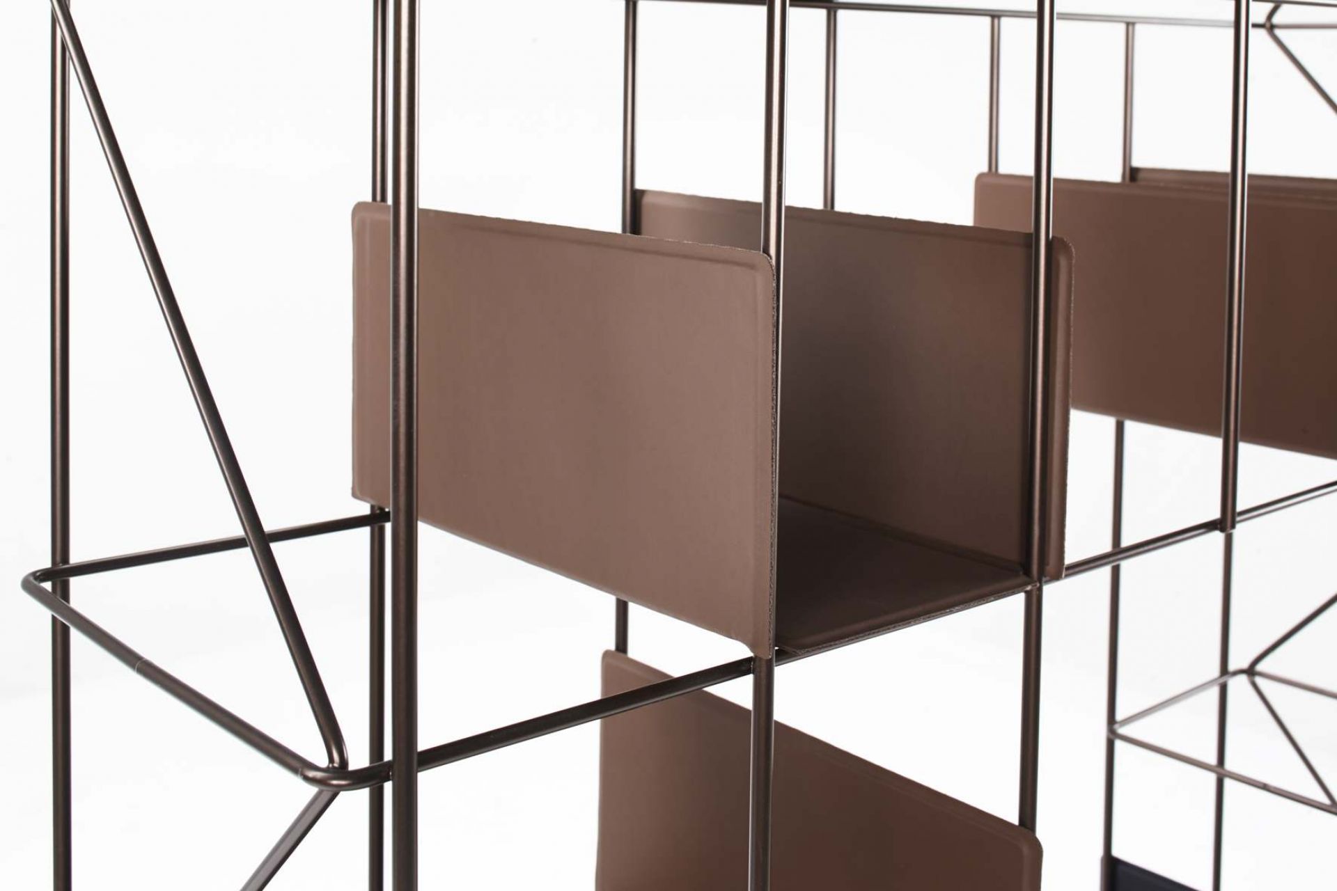 Detailaufnahme des Network Bücherregals von Casamania Horm mit braunen Regalböden und filigranem Metallgestell.