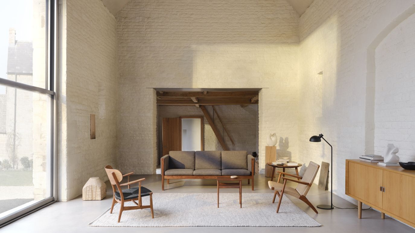Wohnzimmer mit Designmöbeln: Sofa, Sessel, Sideboard und CH004 Nesting Tables Beistelltische 3er Set von Carl Hansen.