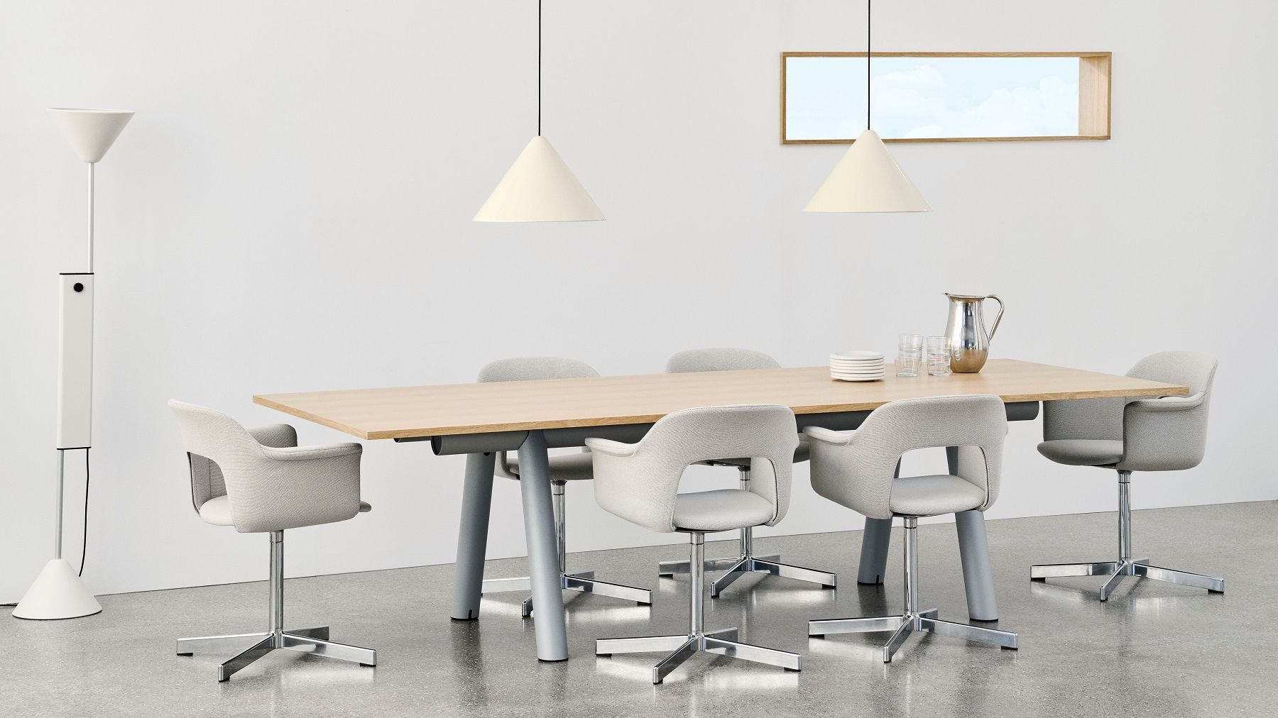 Helle Büroeinrichtung mit Esstisch, Stühlen, Pendelleuchten und Hay Twist Floor Lamp Stehleuchte im Hintergrund.