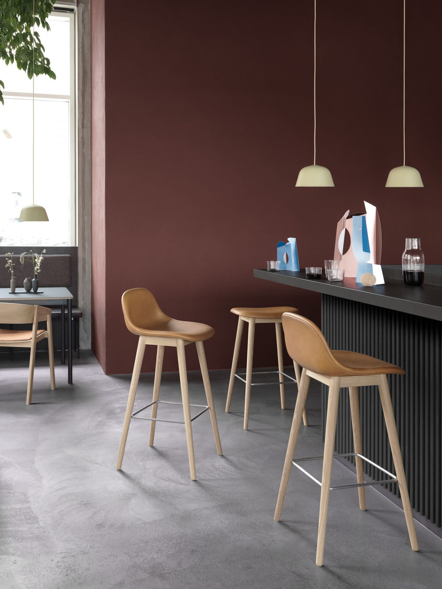 Muuto Fiber Counter Stool Barhocker mit Rückenlehne, hellbrauner Sitz und helle Holzbeine.