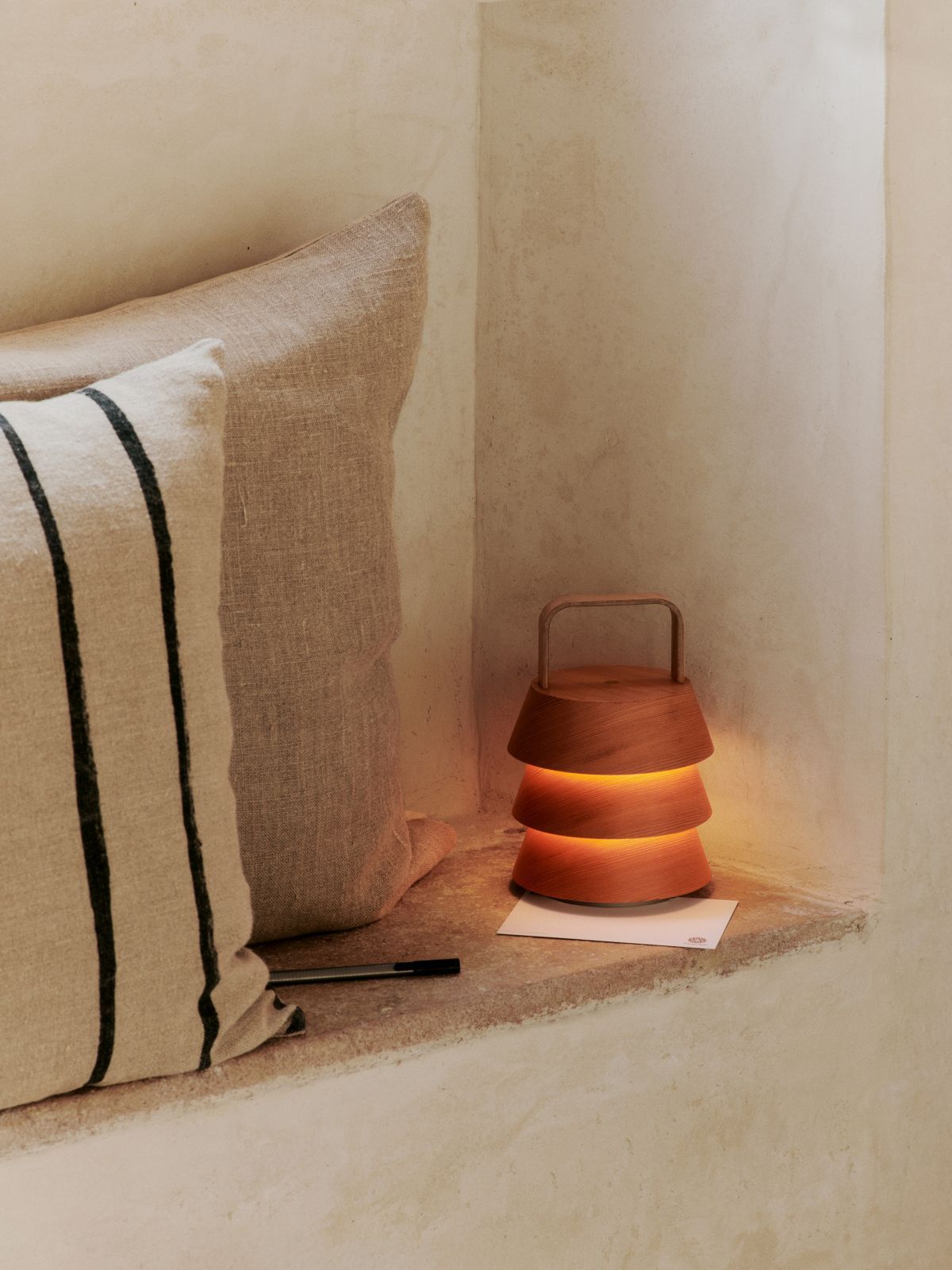 Luver Tischleuchte von Ferm Living aus Holz, warmes Licht auf einem Fensterbrett.