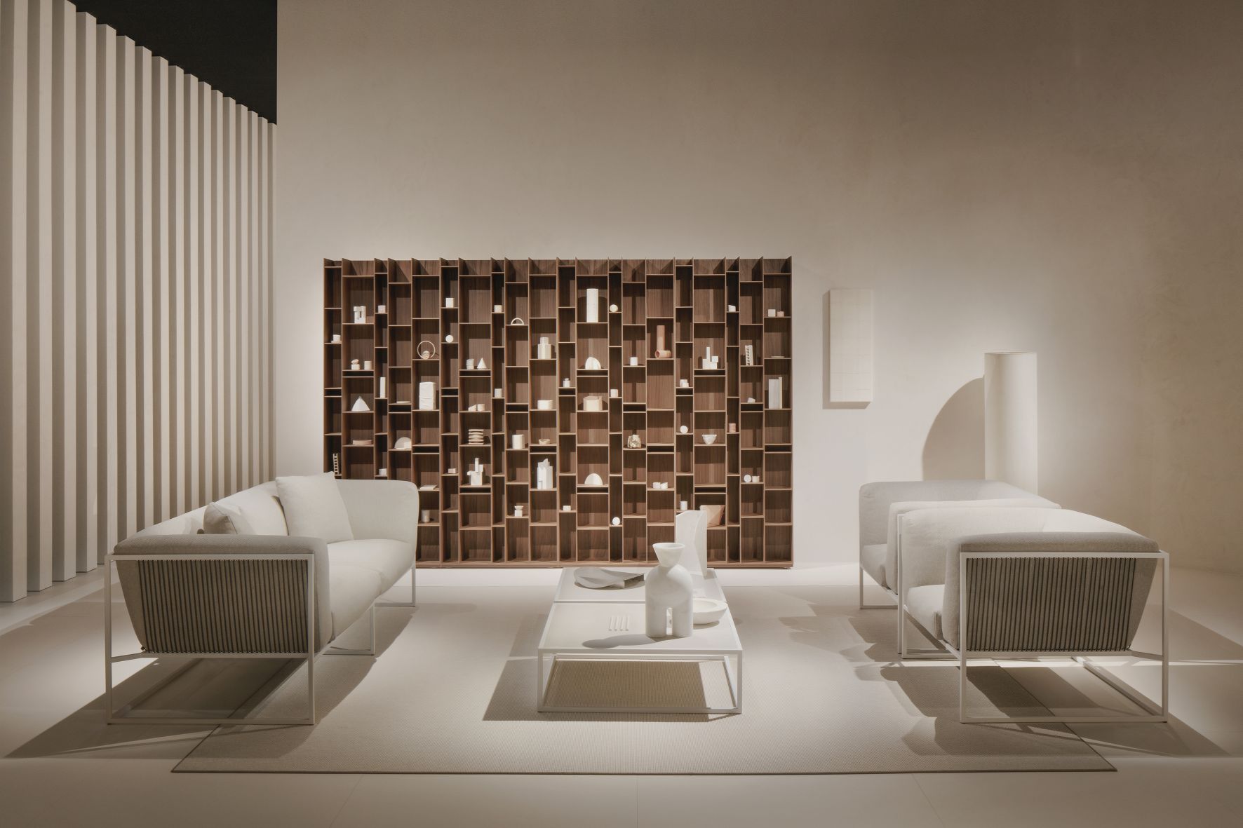 Helles Wohnzimmer mit weißem Arpa Outdoor Sofa von MDF Italia, Couchtisch und Holzregal.