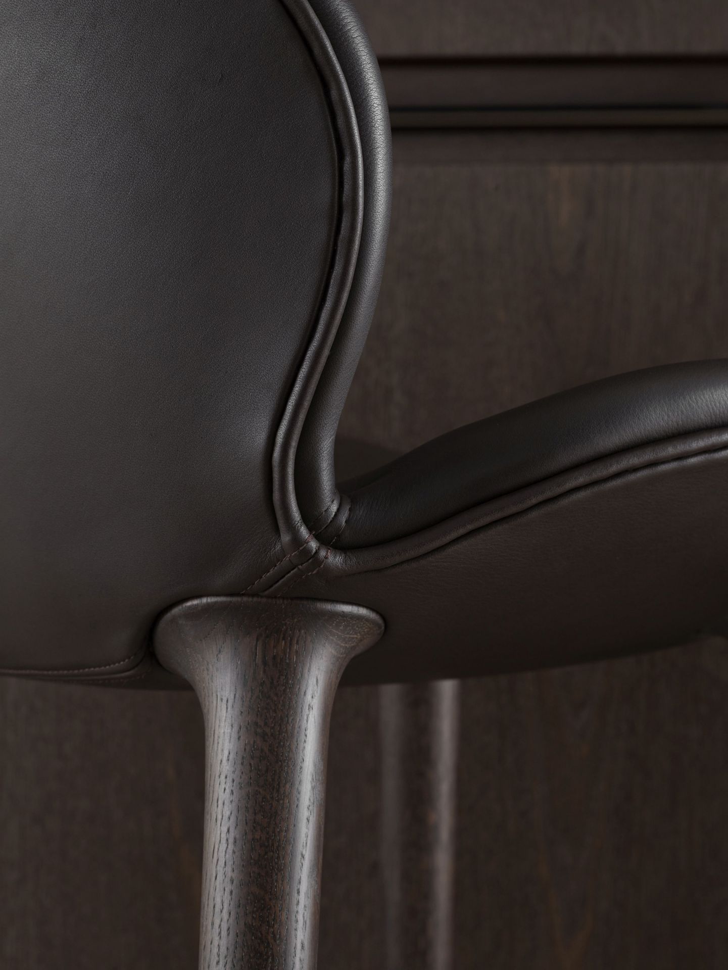 Detailaufnahme des Lodge Tresenhockers von Vipp: Dunkelbraunes Leder auf dunklem Eichenholz, elegante Barhocker für moderne Küchen.