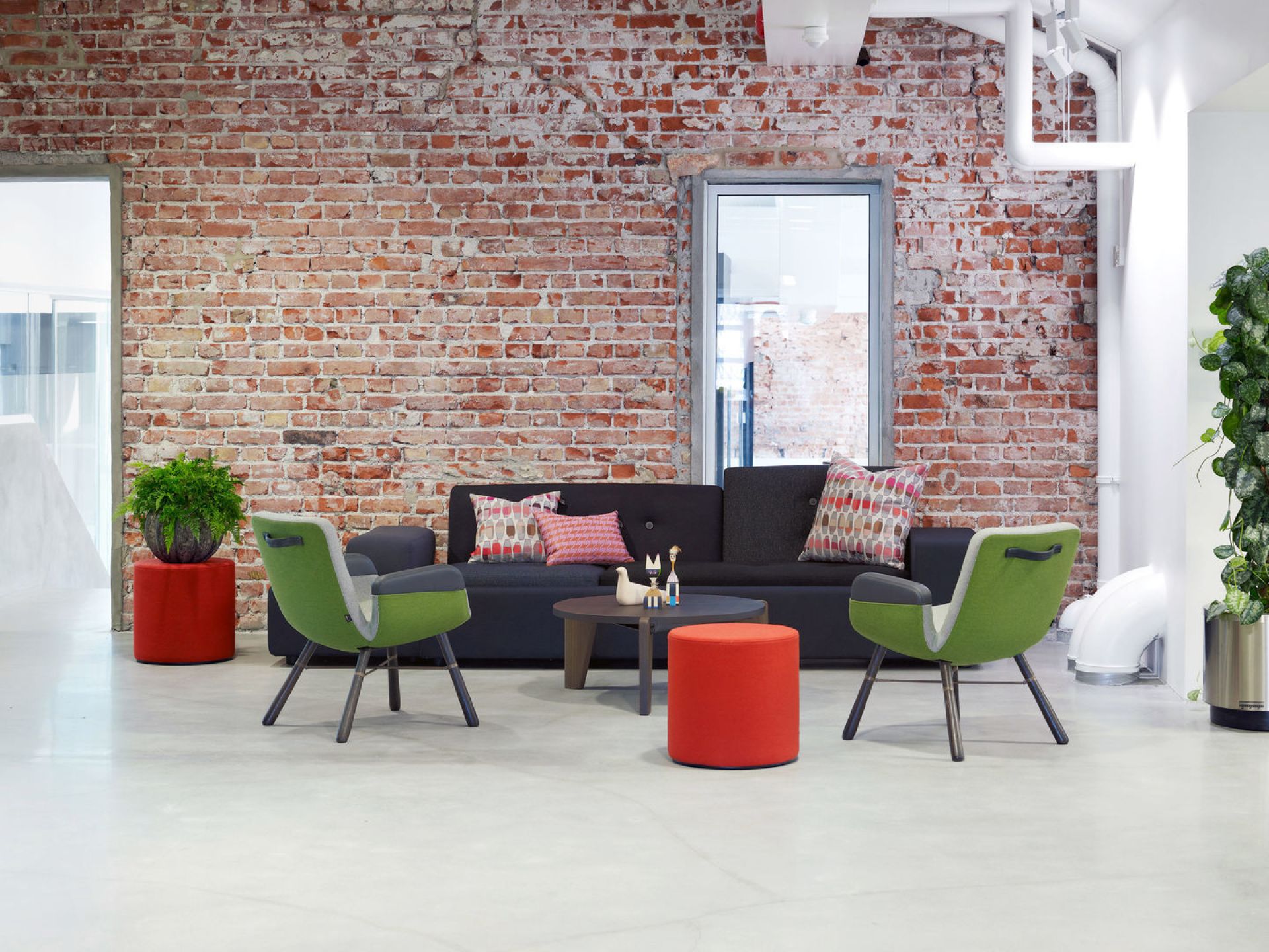 East River Chair von Vitra in Grün und Grau vor einer Backsteinwand im Wohnzimmer.