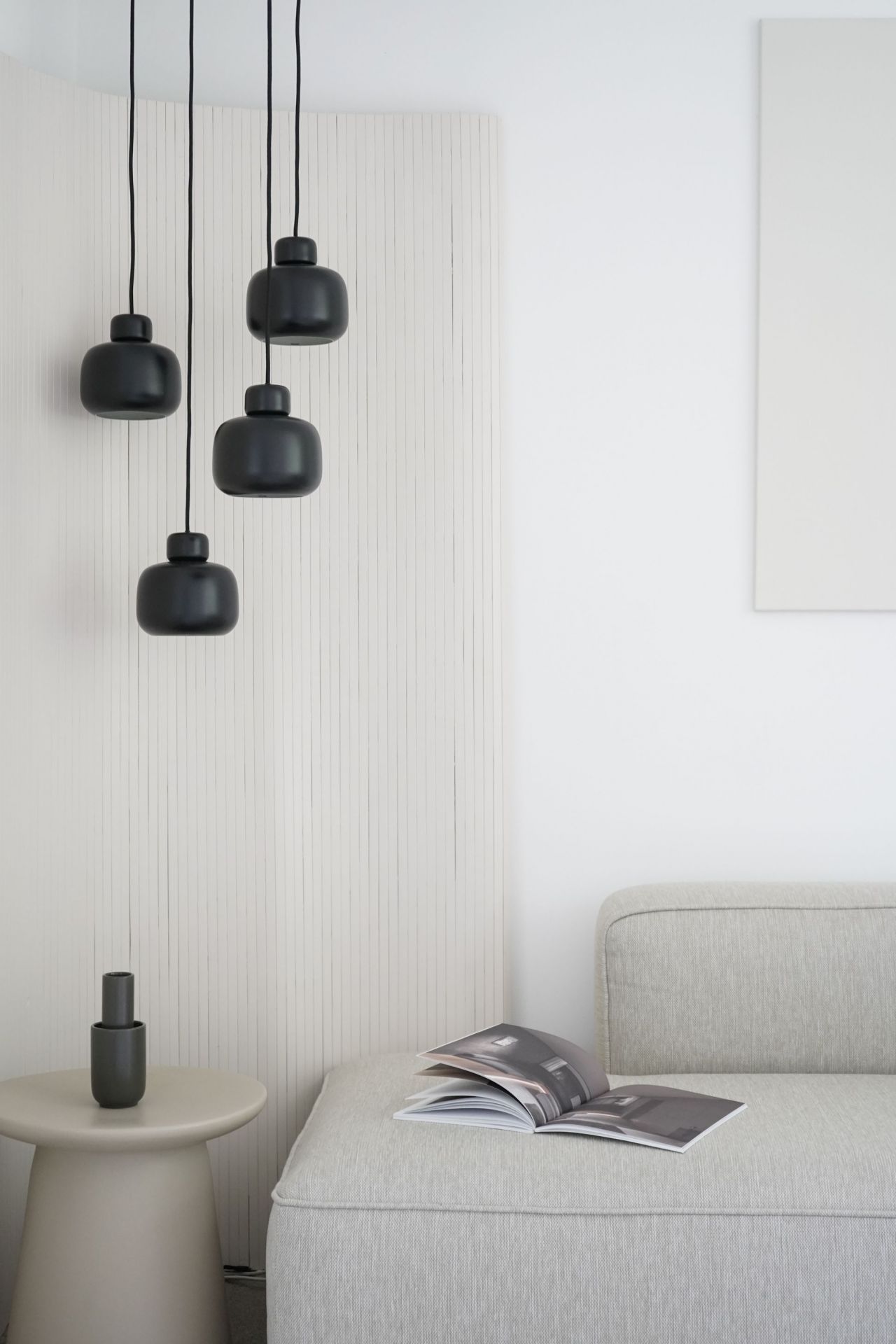 Nahaufnahme von drei kleinen schwarzen Stone Pendant Pendelleuchten von Woud im modernen Wohnzimmer.