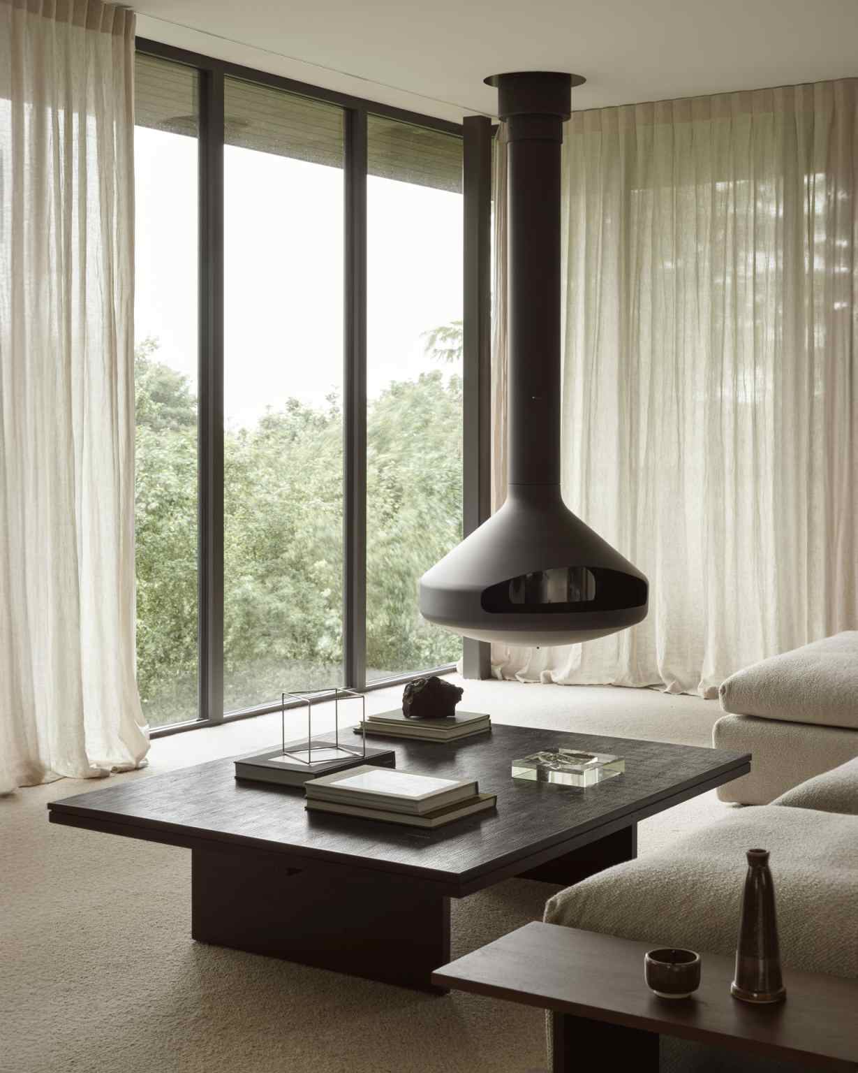 Ethnicraft Grooves Coffee Table: Quadratischer Couchtisch aus dunklem Holz in modernem Wohnzimmer mit Kamin.