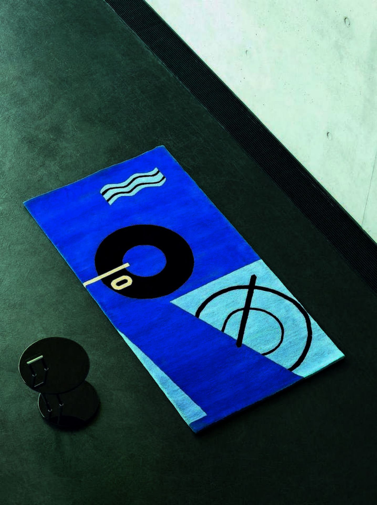 Blauer Teppich mit abstrakten Mustern und ClassiCon Occasional Table Beistelltisch im Hintergrund.
