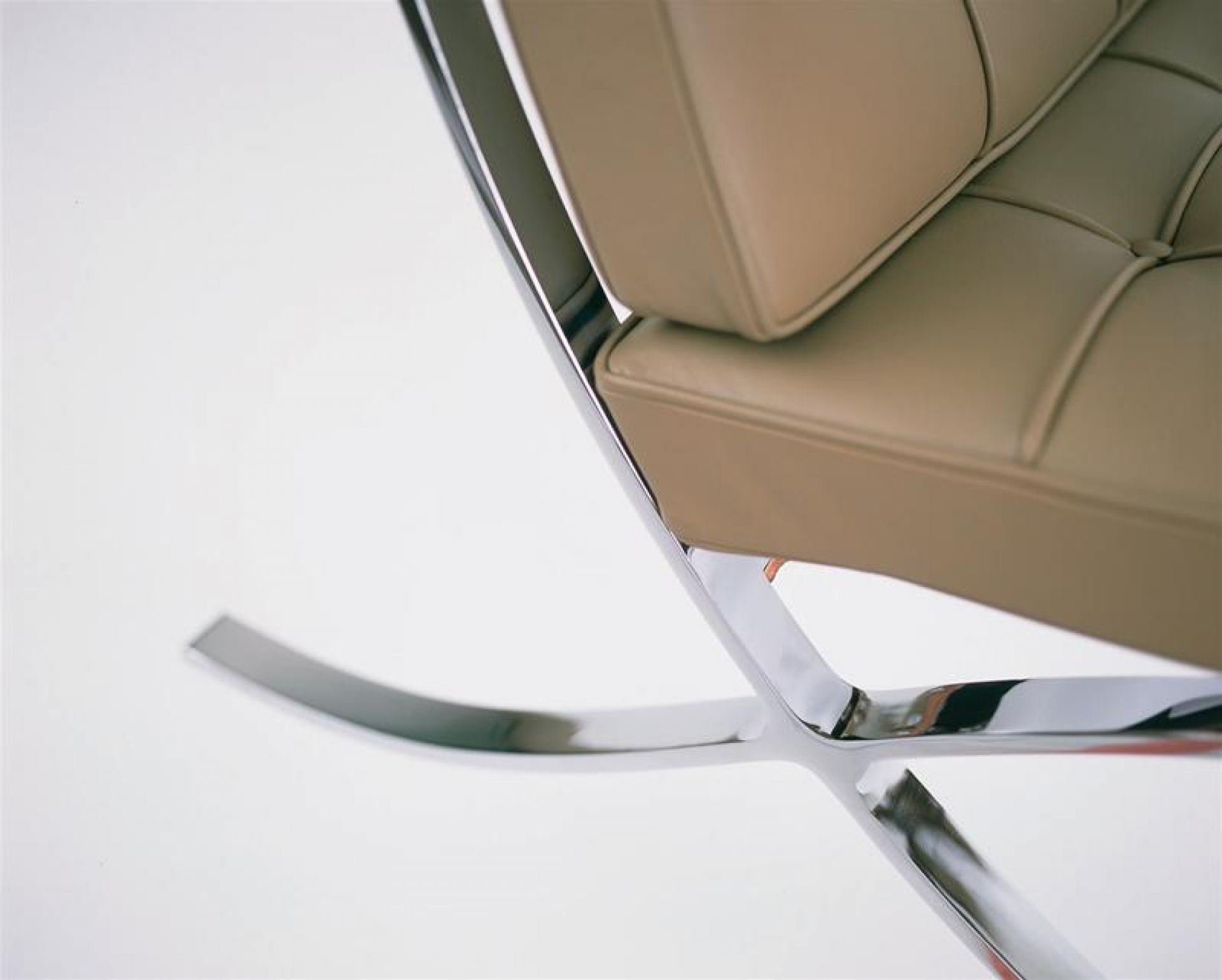 Detailaufnahme: Barcelona Sessel von Knoll International, beiges Leder, verchromter Stahlrahmen, modernes Design.