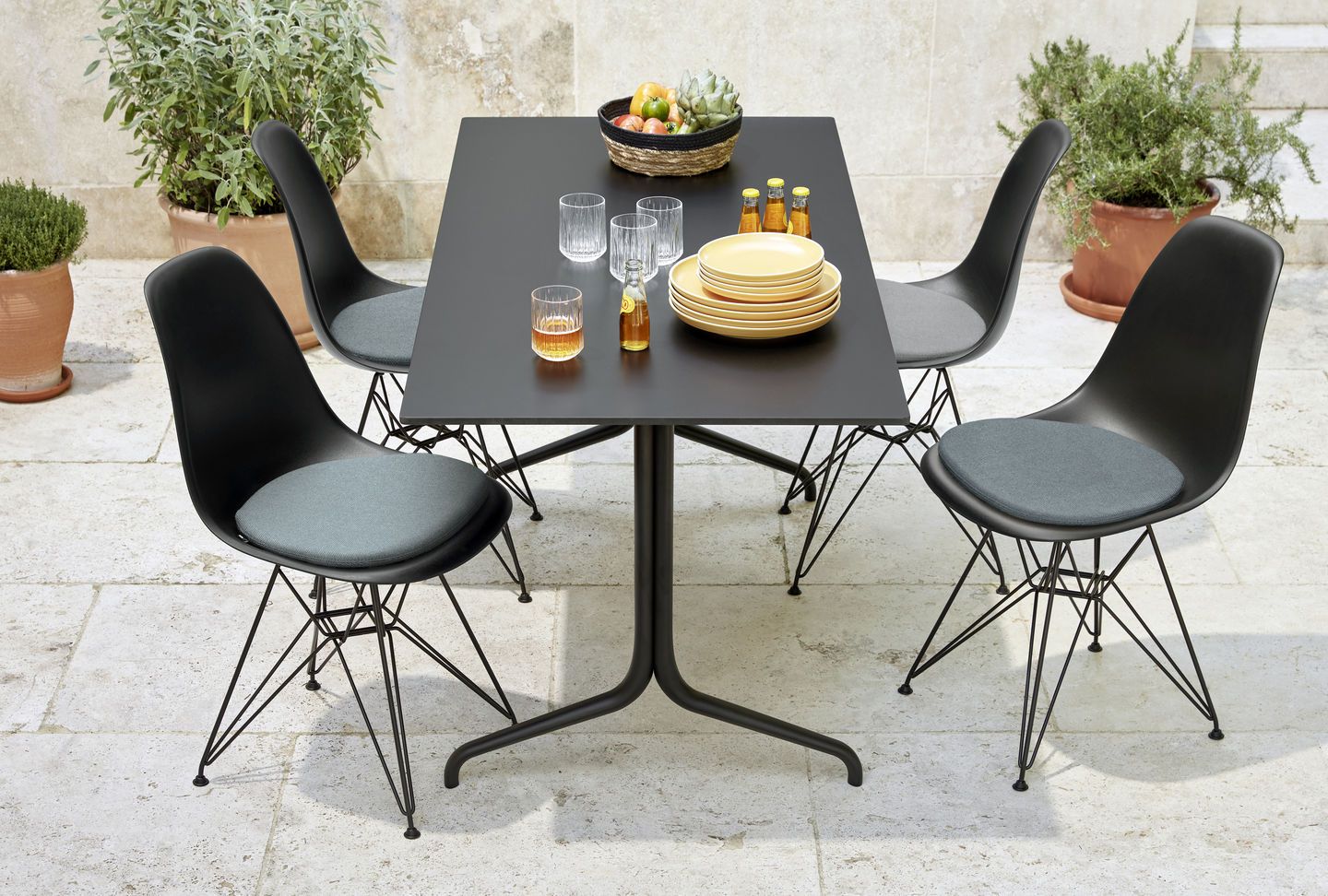 Eames Fiberglass Chair DSR Stuhl von Vitra mit Sitzpolster an Esstisch im Garten.