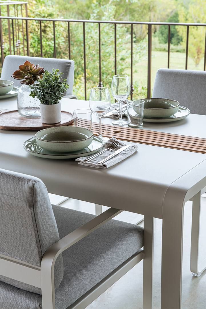 Bellevie Sessel Outdoor Fermob: Detailaufnahme eines gedeckten Gartentisches mit grauen Sesseln und Geschirr.