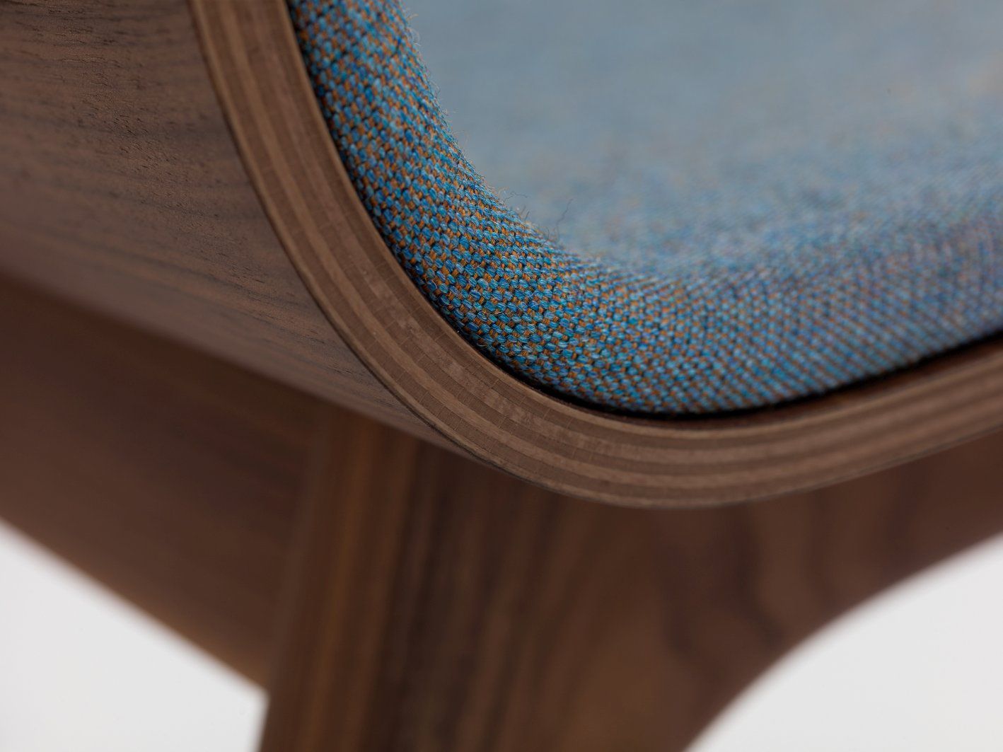 Detailaufnahme: Morph Holzstuhl mit blauem Sitzpolster, modernes Design, bequemer Sitzkomfort.
