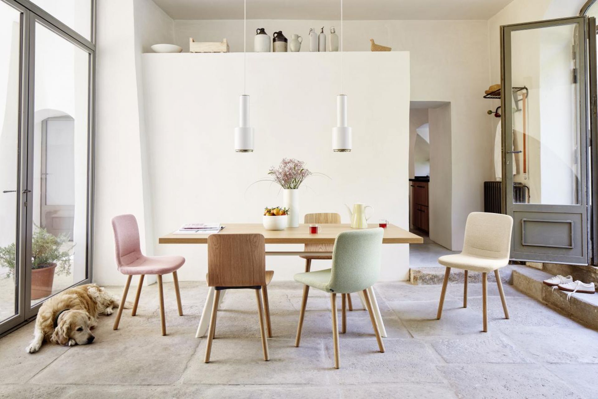 Esszimmer mit Holztisch und vier Hal Stühlen von Vitra in verschiedenen Farben.