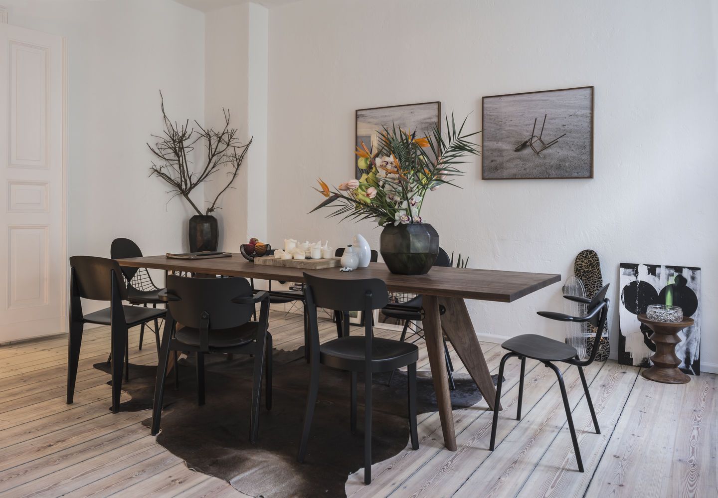 Esszimmer mit Holztisch und schwarzen DKW Wire Chairs von Vitra mit Sitzkissen.