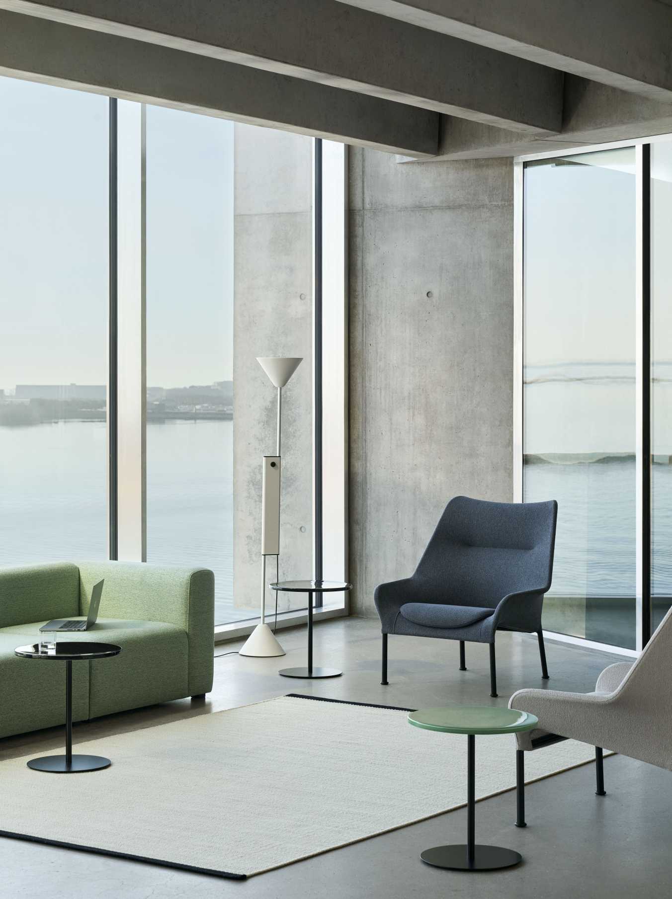Hay 02 Lounge Chair Sessel in grau in modernem Wohnzimmer mit Sofa und Meerblick.
