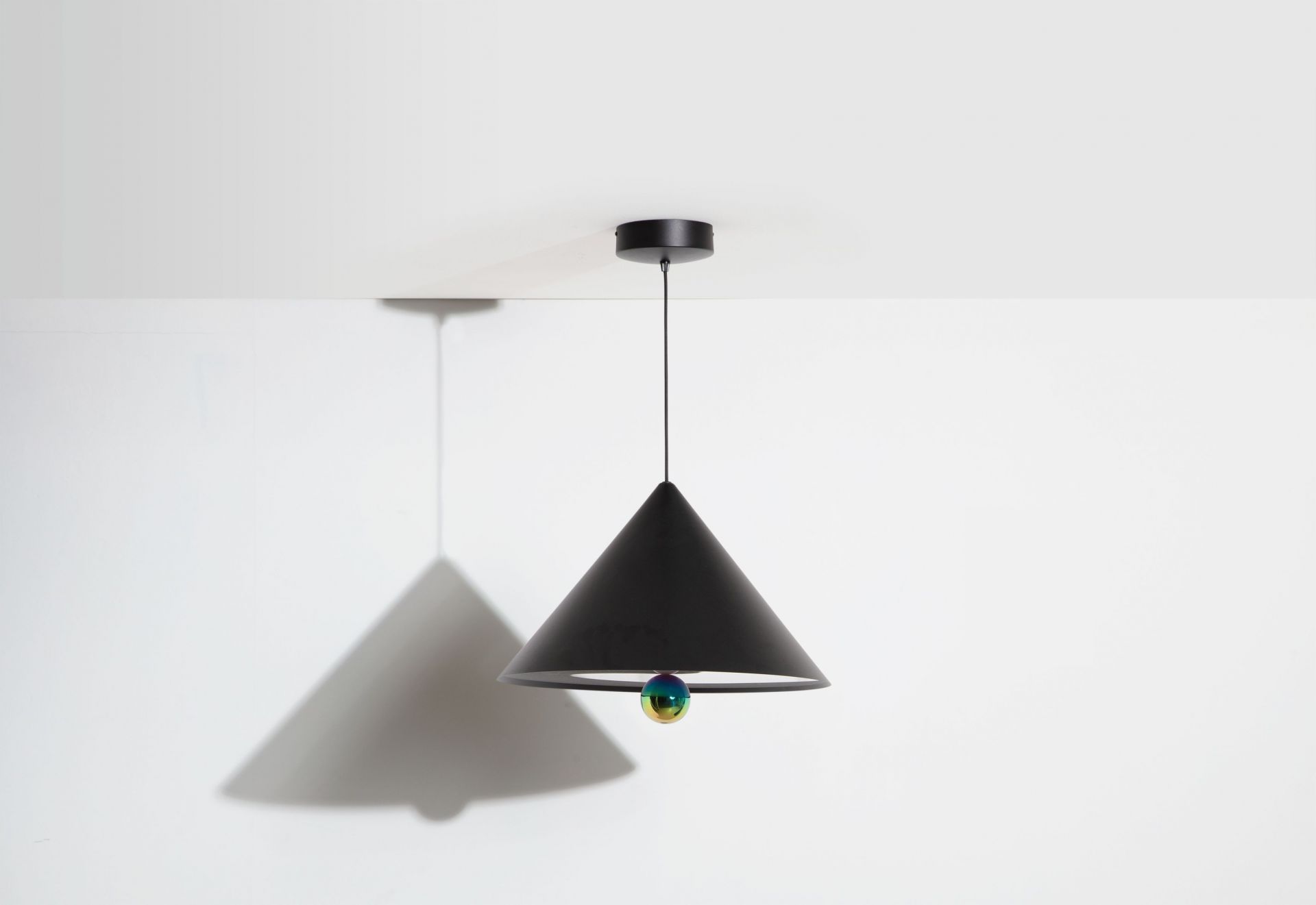 Schwarze Cherry Pendelleuchte von Petite Friture mit schimmernder Kugel und Kegelform vor weißem Hintergrund.