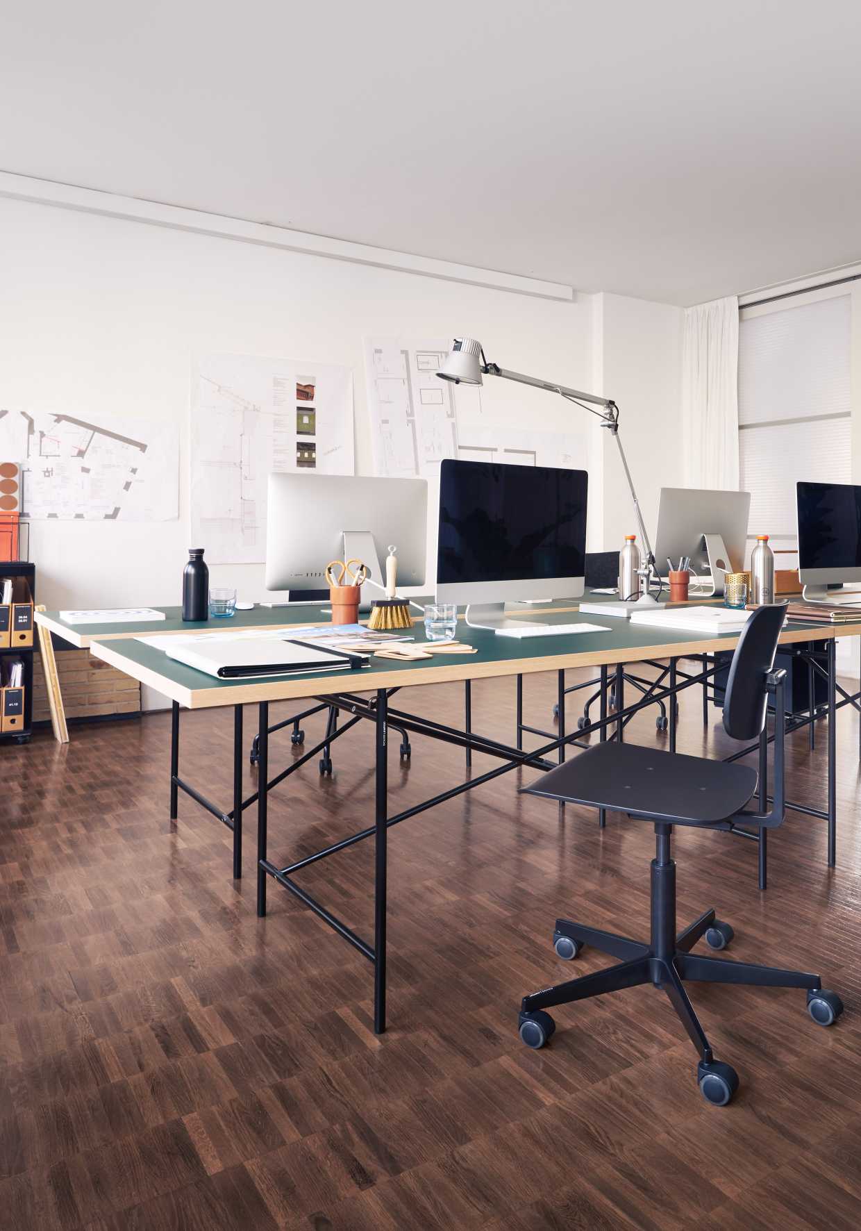 Helles Büro mit mehreren Eiermann Tischgestellen von Richard Lampert, genutzt als Arbeitsplätze mit Computern.