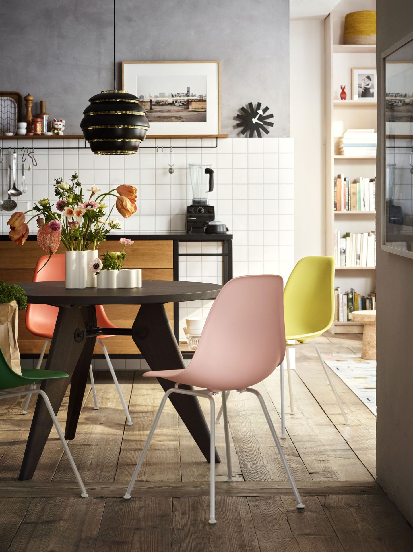 Esszimmer mit Esstisch und farbigen Eames Fiberglass Stühlen DSX mit Sitzpolster von Vitra.