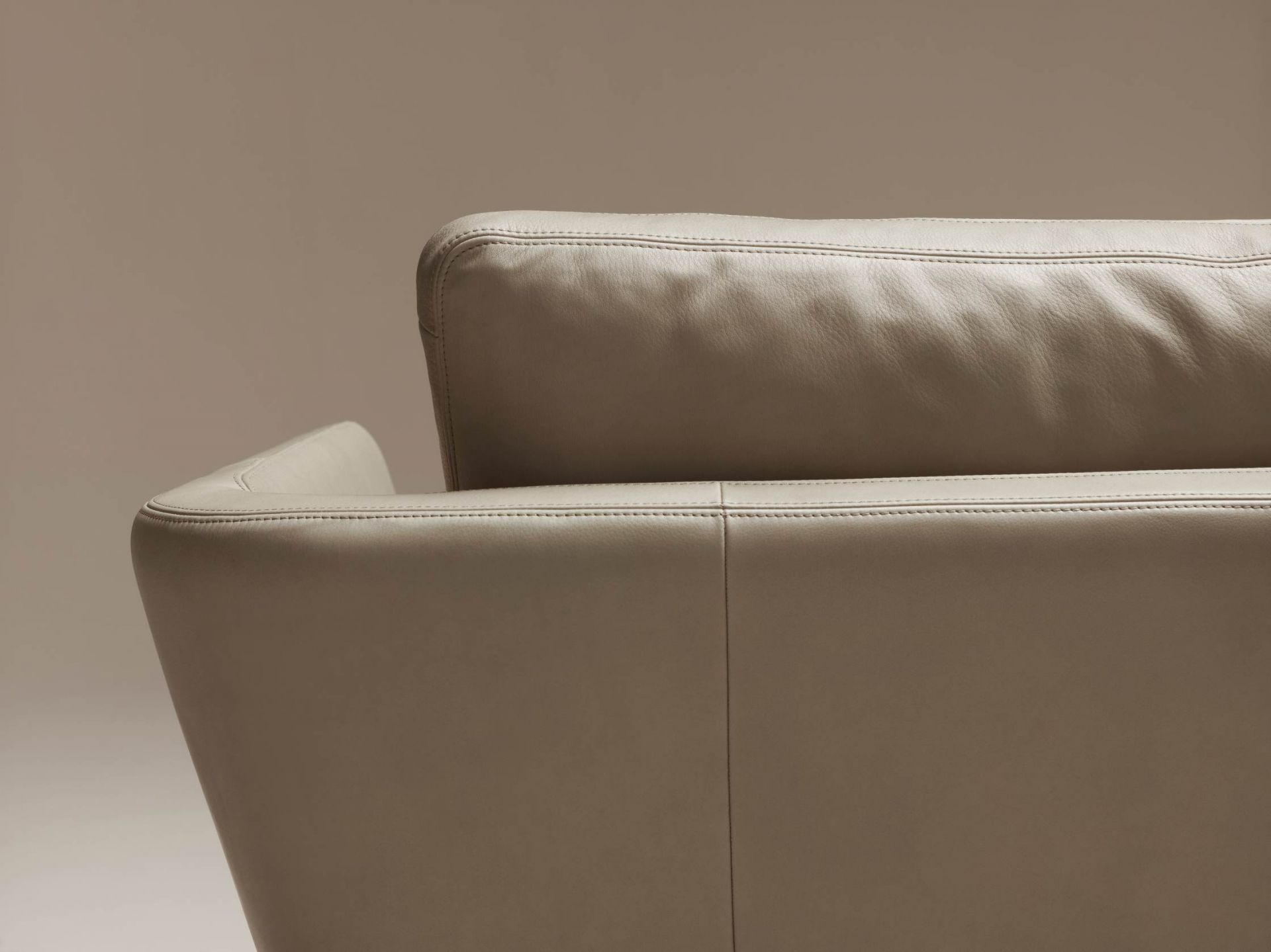 Detailaufnahme des Suita Sofas von Vitra, ein modernes Ledersofa in Beige mit feinen Ziernähten.