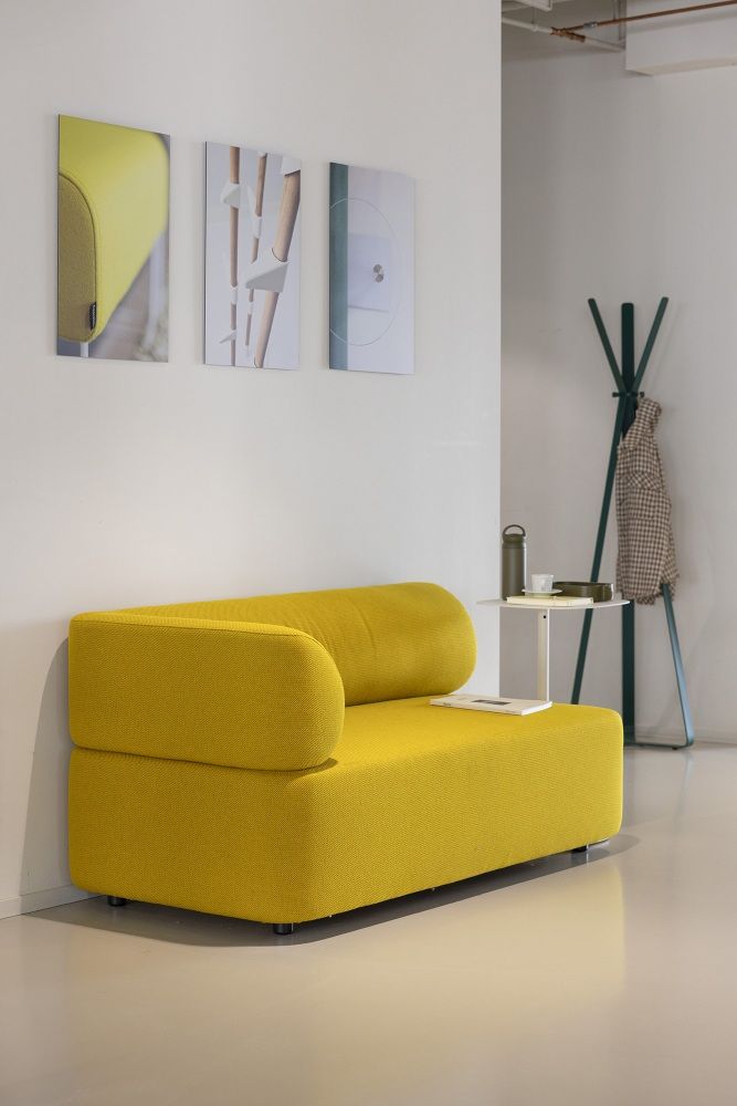 Gelbes Cascando Mezza Sitzelement Sofa mit abgerundeter Armlehne und minimalistischem Design für moderne Wohnräume.
