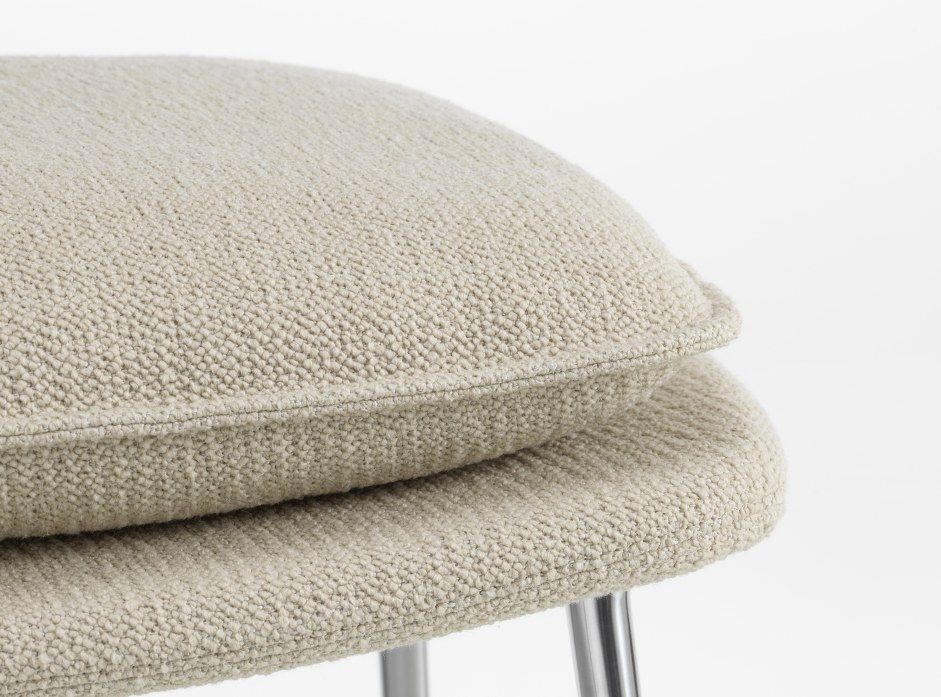 Detailaufnahme des Vitra Slow Chair Ottoman mit beigem Stoffbezug und Chromfüßen.