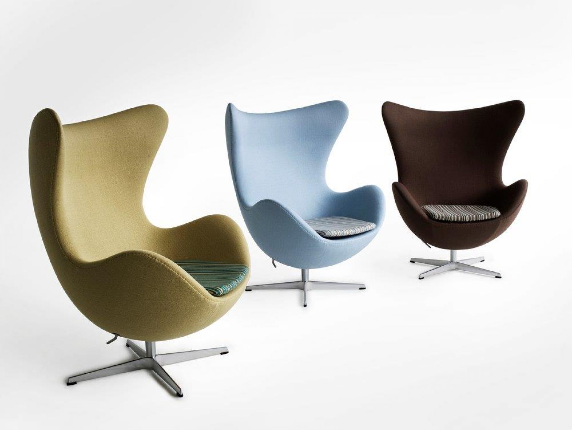 Drei "Das Ei" Sessel von Fritz Hansen in Gelb, Blau und Braun mit gestreiften Sitzkissen.