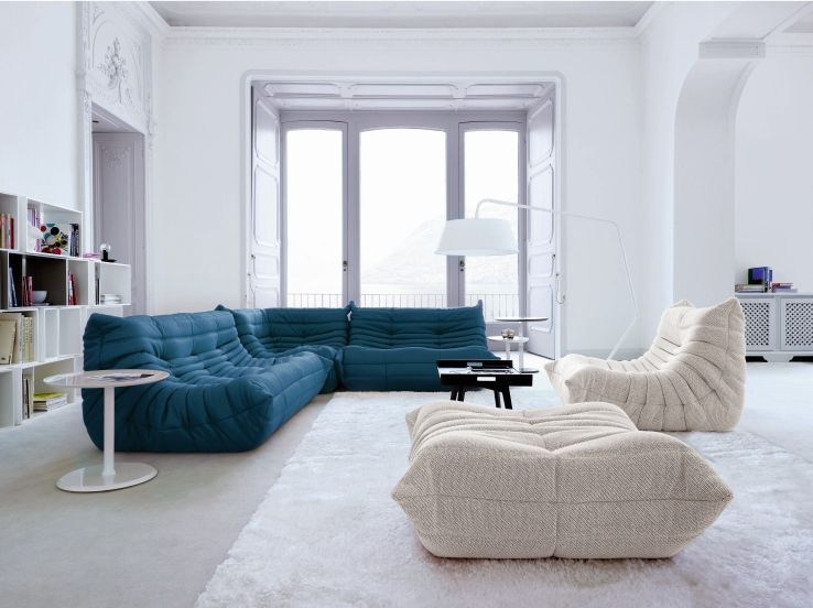 Blauer Togo Sessel von ligne roset mit passendem Sessel und Hocker in modernem Wohnzimmer.