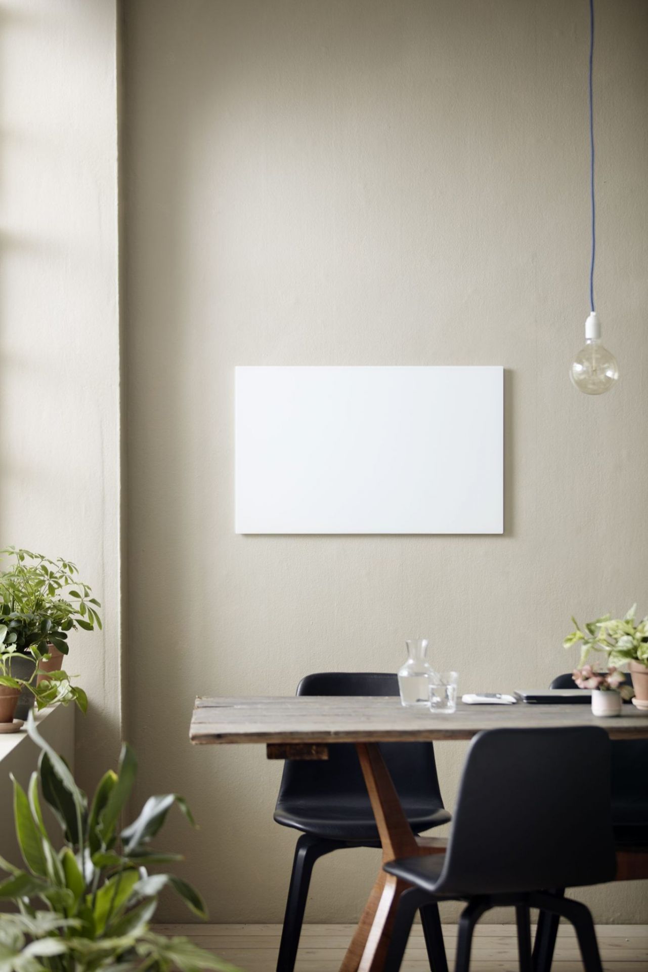 Helle Chat Board Classic Glastafel als magnetische Wandtafel über einem Esstisch in einem modernem Esszimmer.