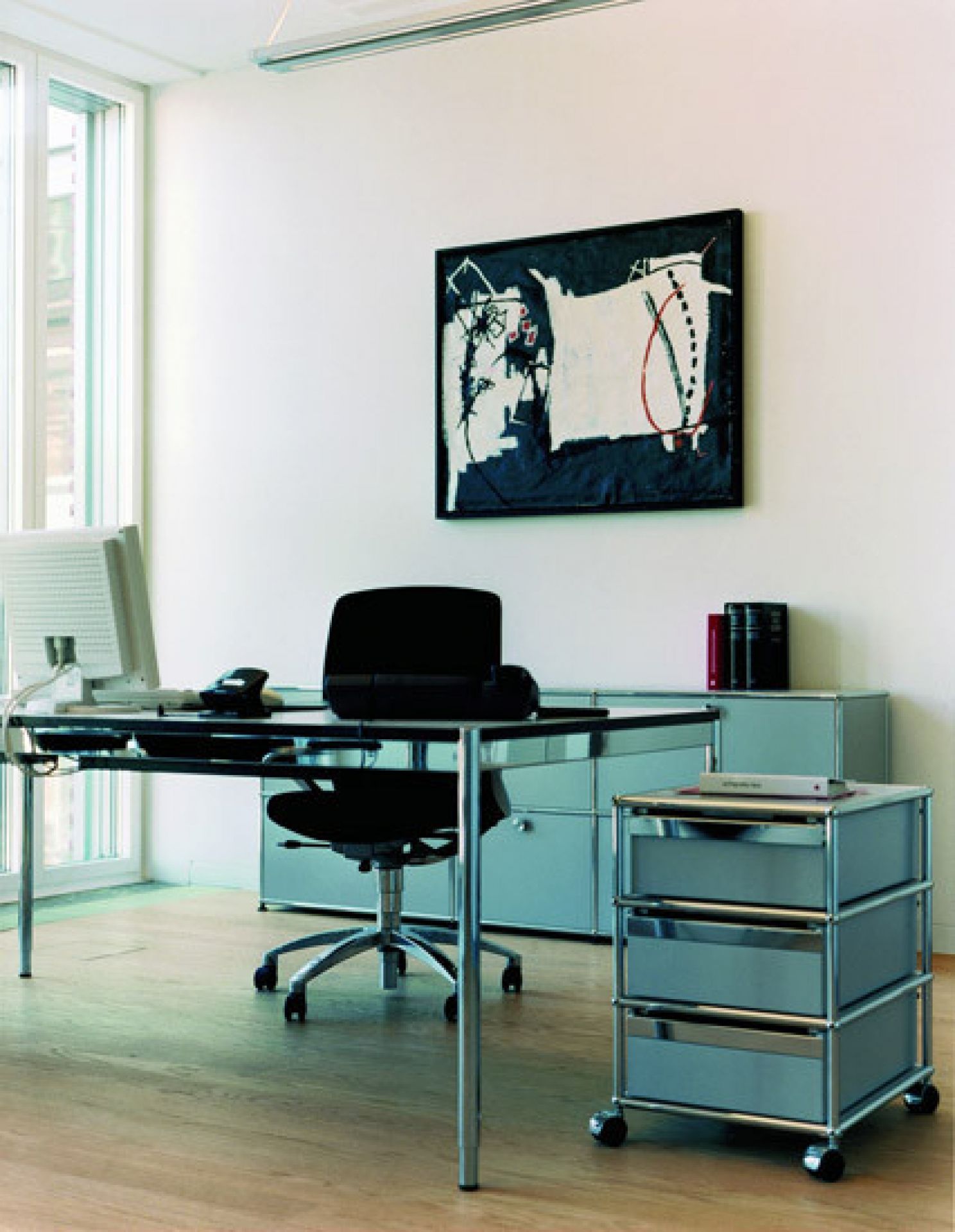 Büro mit USM Haller Tisch, Rollcontainer und Sideboard in Hellgrau, modernes Design für Arbeitszimmer.