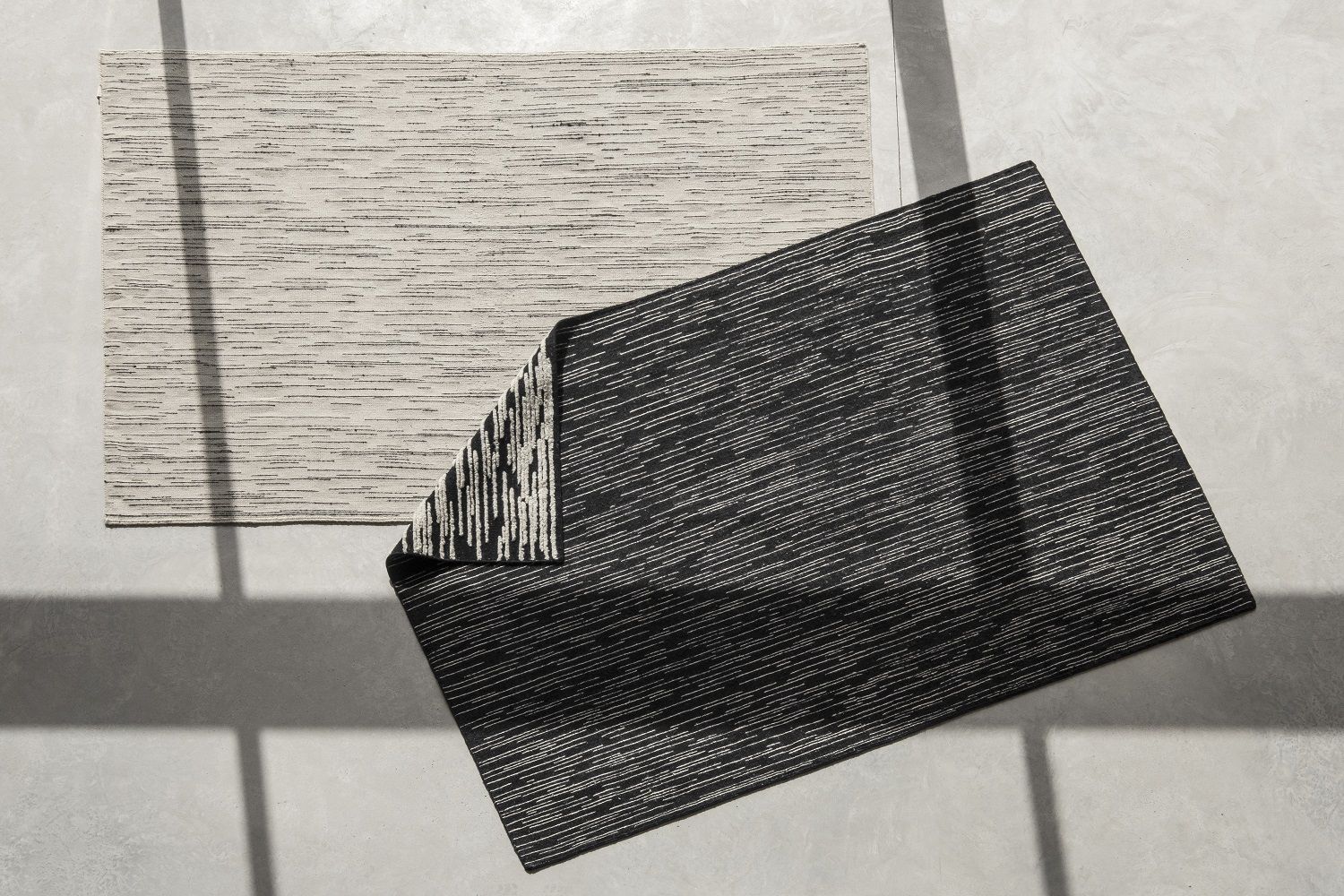 Nanimarquina Doblecara Teppich, rechteckig, mit abstraktem Streifenmuster in Schwarz und Beige, modernes Wohnaccessoire.