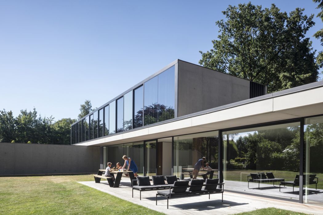 Sol + Luna Outdoor Sofa-Sonnenliege von Extremis auf Terrasse vor modernem Haus mit Familie im Garten.