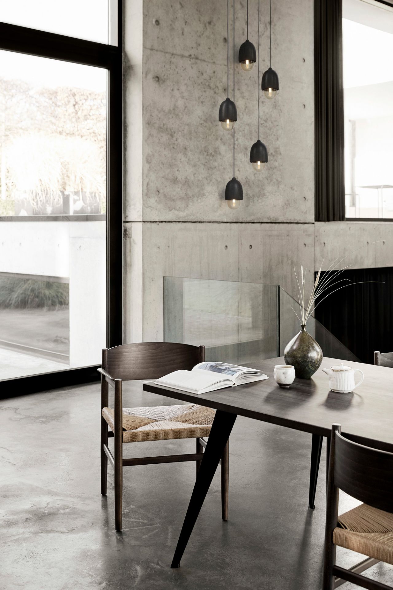 Moderner Esstisch von Mater mit Holzstühlen und minimalistischer Pendelleuchte in einem stilvollen Esszimmer.