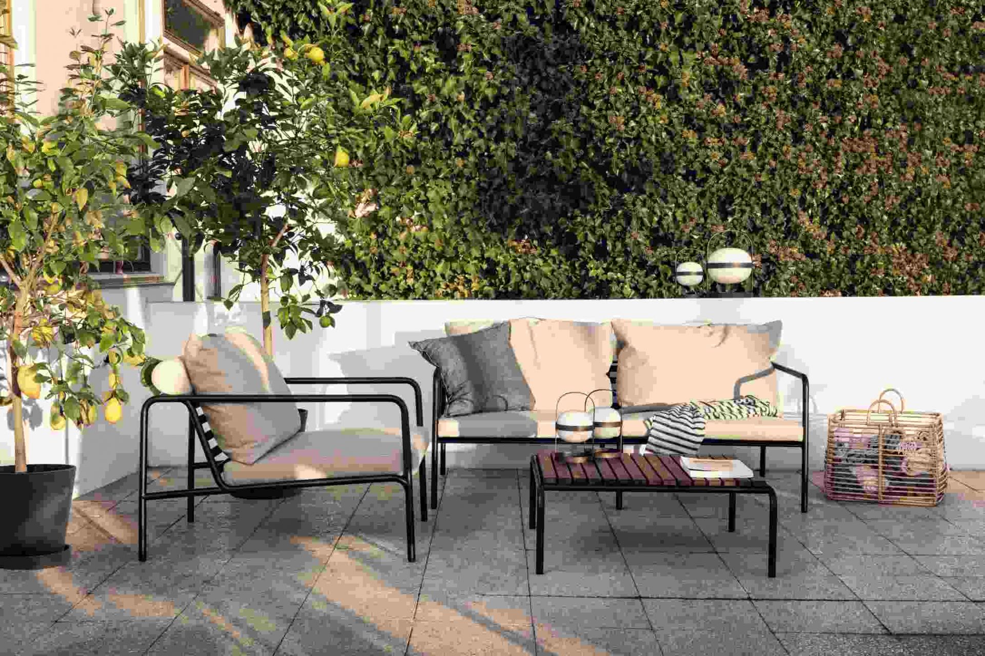 Avon 2-Sitzer Sofa von Houe für den Außenbereich mit Sessel und Tisch auf Terrasse.