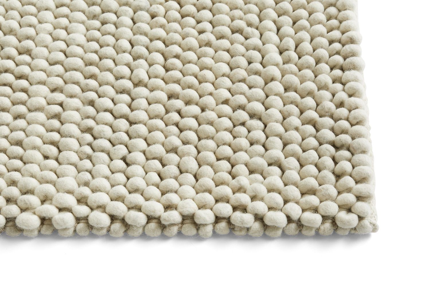 Detailansicht des Hay Peas Teppichs (240x170 cm) in Wollweiß. Strukturierter, runder Wollteppich.