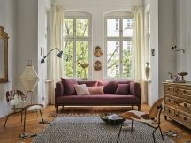 Wohnzimmer mit Sofa und Vitra Kissen in Rosa- und Lilatönen, dekorative Sofakissen für gemütliches Ambiente.