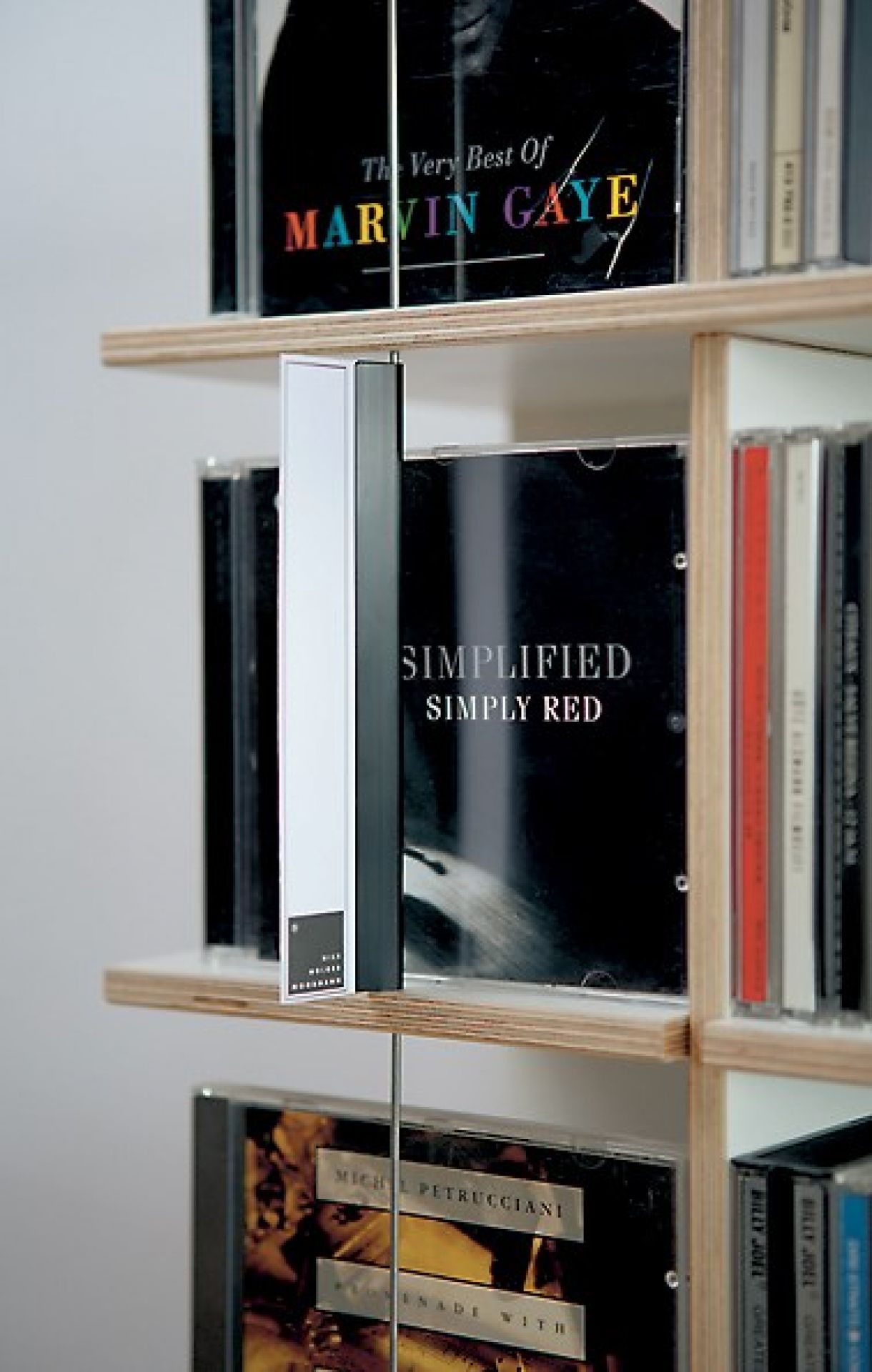 Detailaufnahme des Musikstapler CD-Regals von Nils Holger Moormann, gefüllt mit CDs verschiedener Künstler.