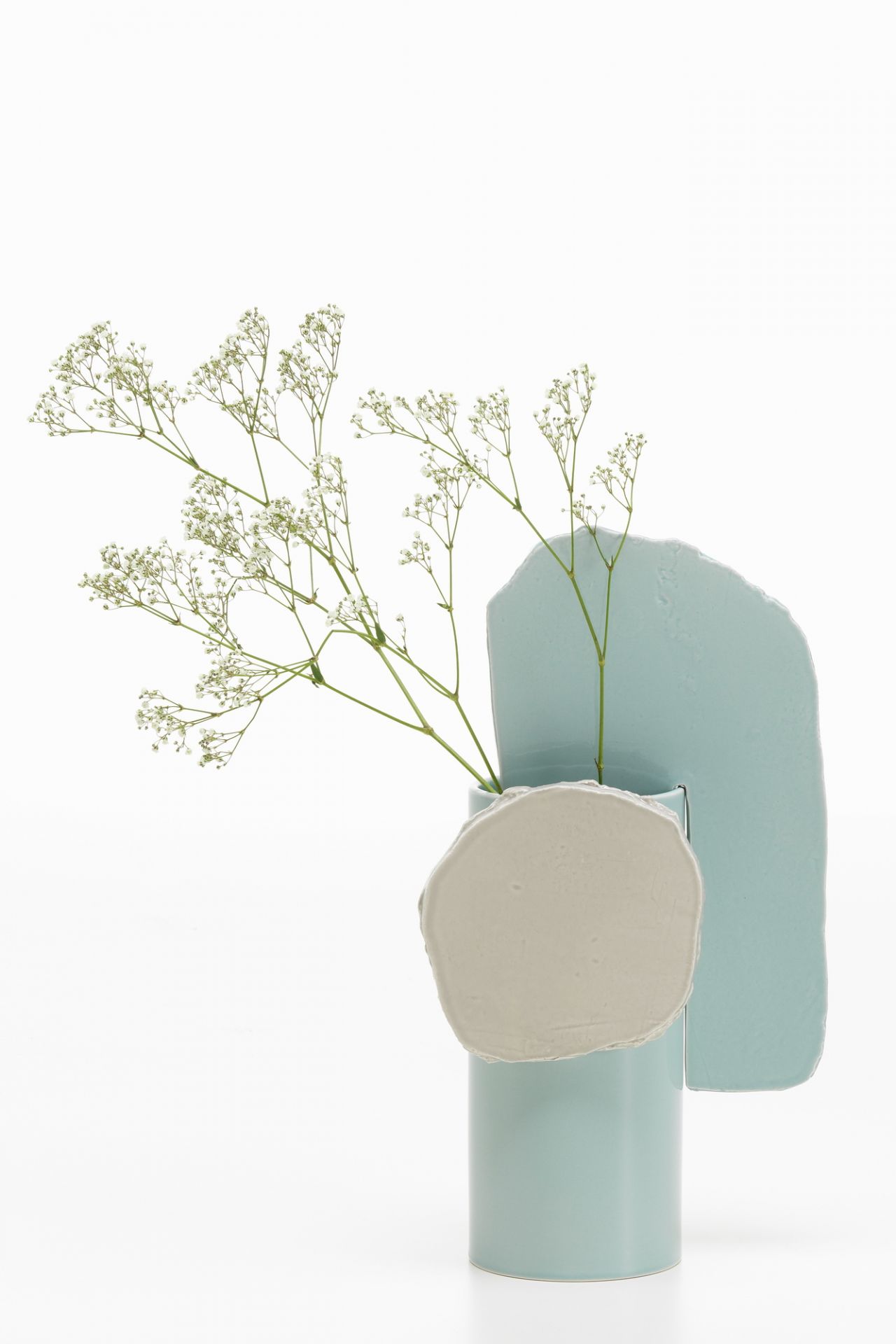 Vitra Découpage Vase: Moderne Blumenvase in hellblau und beige mit zarten weißen Blüten.