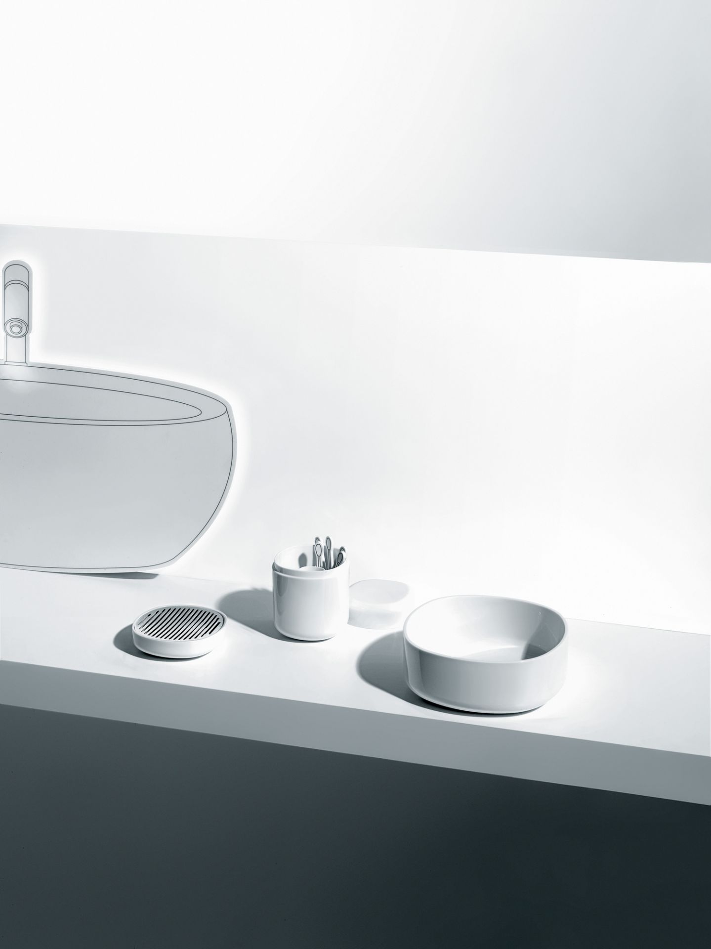 Weiße Birillo Seifenschale von Alessi, zusammen mit Zahnputzbecher und Seifenspender im minimalistischen Badezimmer.