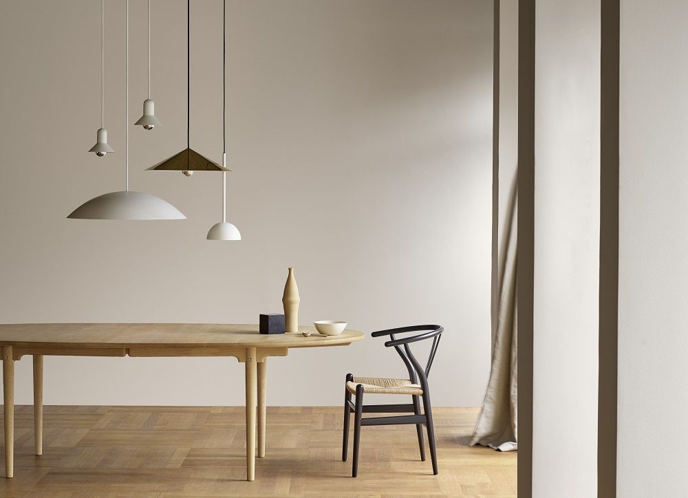 CH24 Wishbone Chair Stuhl in Orange-Rot von Carl Hansen & Søn am Esstisch.