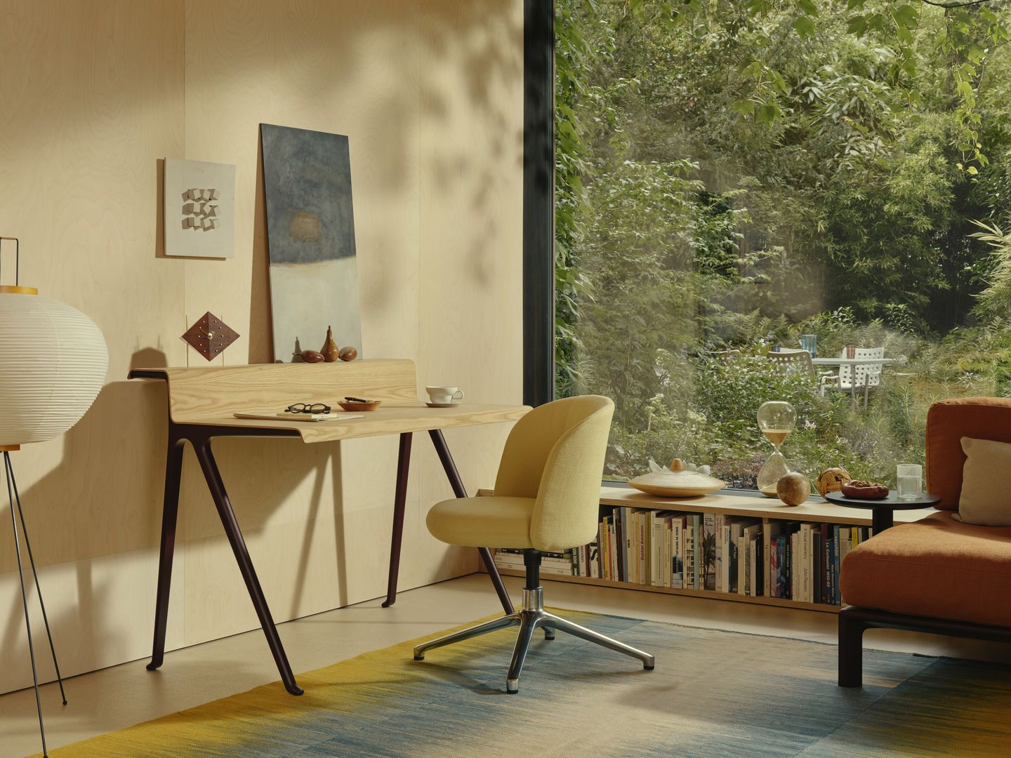 Vitra Courier Schreibtisch aus hellem Holz mit dunklen Beinen in modernem Arbeitszimmer.
