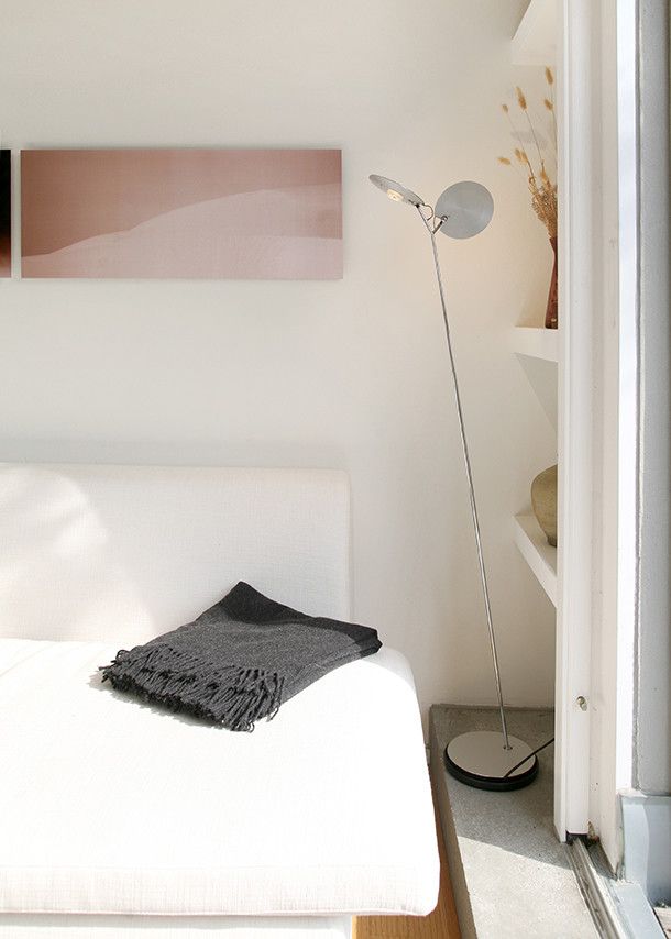 OyO S Stehleuchte von Baltensweiler im modernen Wohnzimmer neben Sofa und Regal.