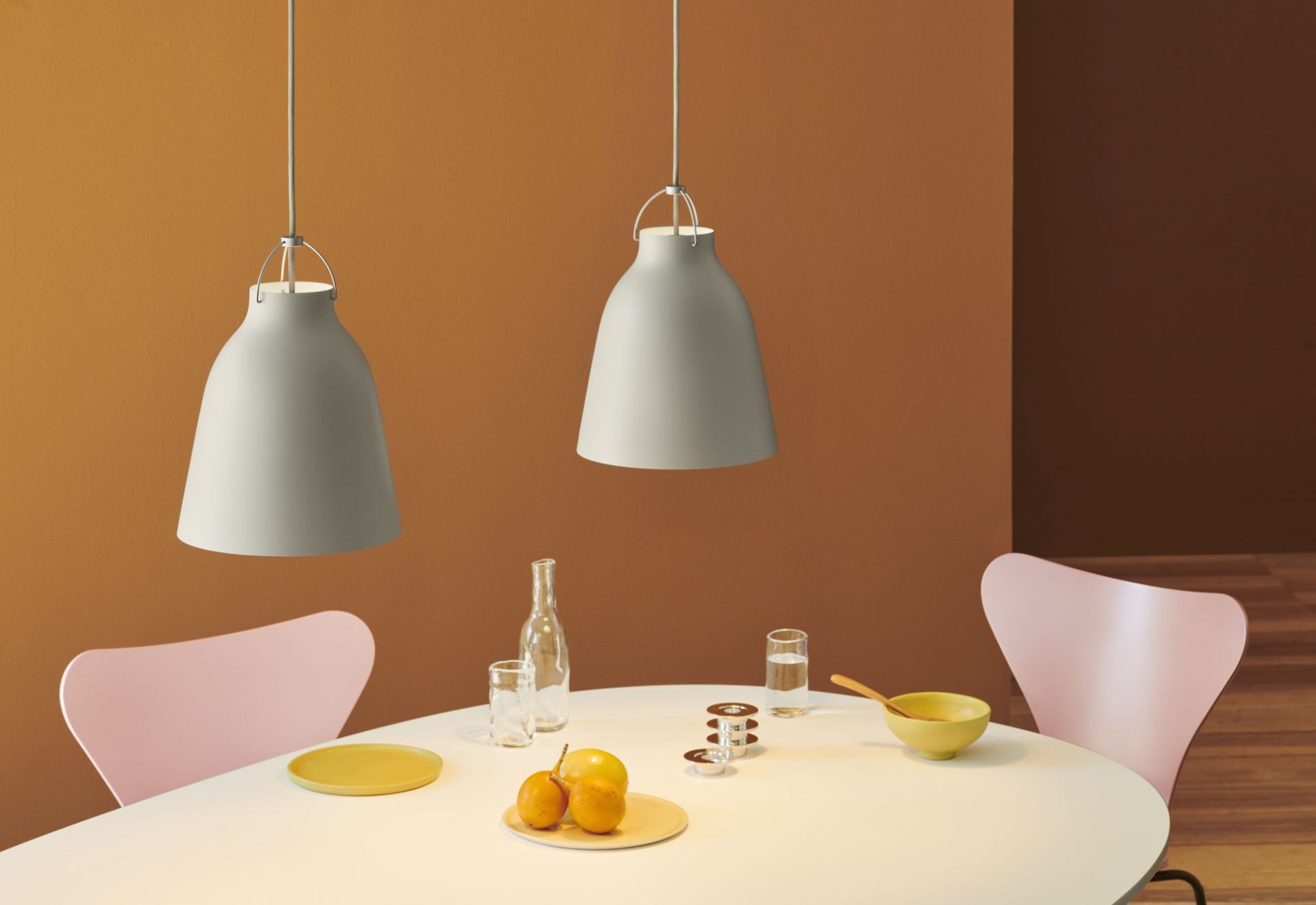 Fritz Hansen Super Elliptisch Esstisch mit Pendelleuchten, Stühlen und Tischdekoration in einem modernen Esszimmer.