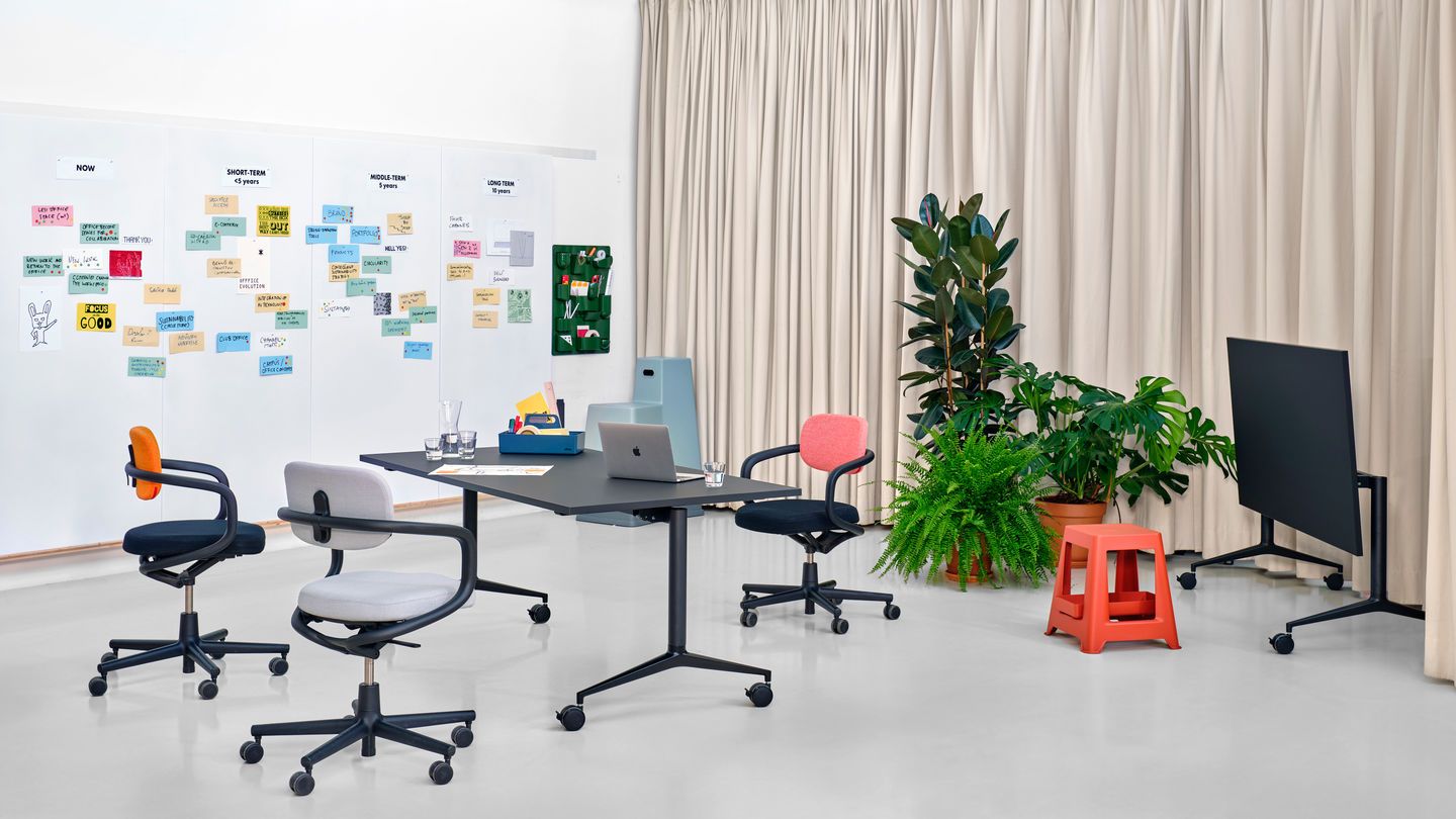 Vitra MedaMorph Klapptisch in einem modernen Büro mit Bürostühlen, Whiteboard und Pflanzen.