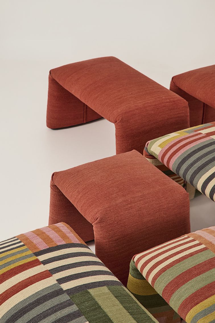 Nanimarquina Folded Colors Bank, safranrote Sitzbank und gestreifte Kissen, moderne Wohnaccessoires.