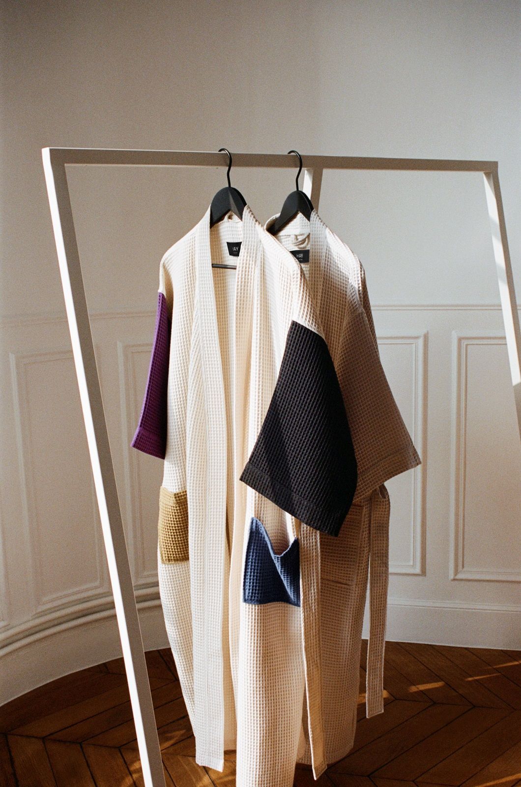 Hay Loop Stand Wardrobe Garderobe mit zwei farbigen Waffel-Bademänteln auf Kleiderbügeln an einer weißen Kleiderstange.