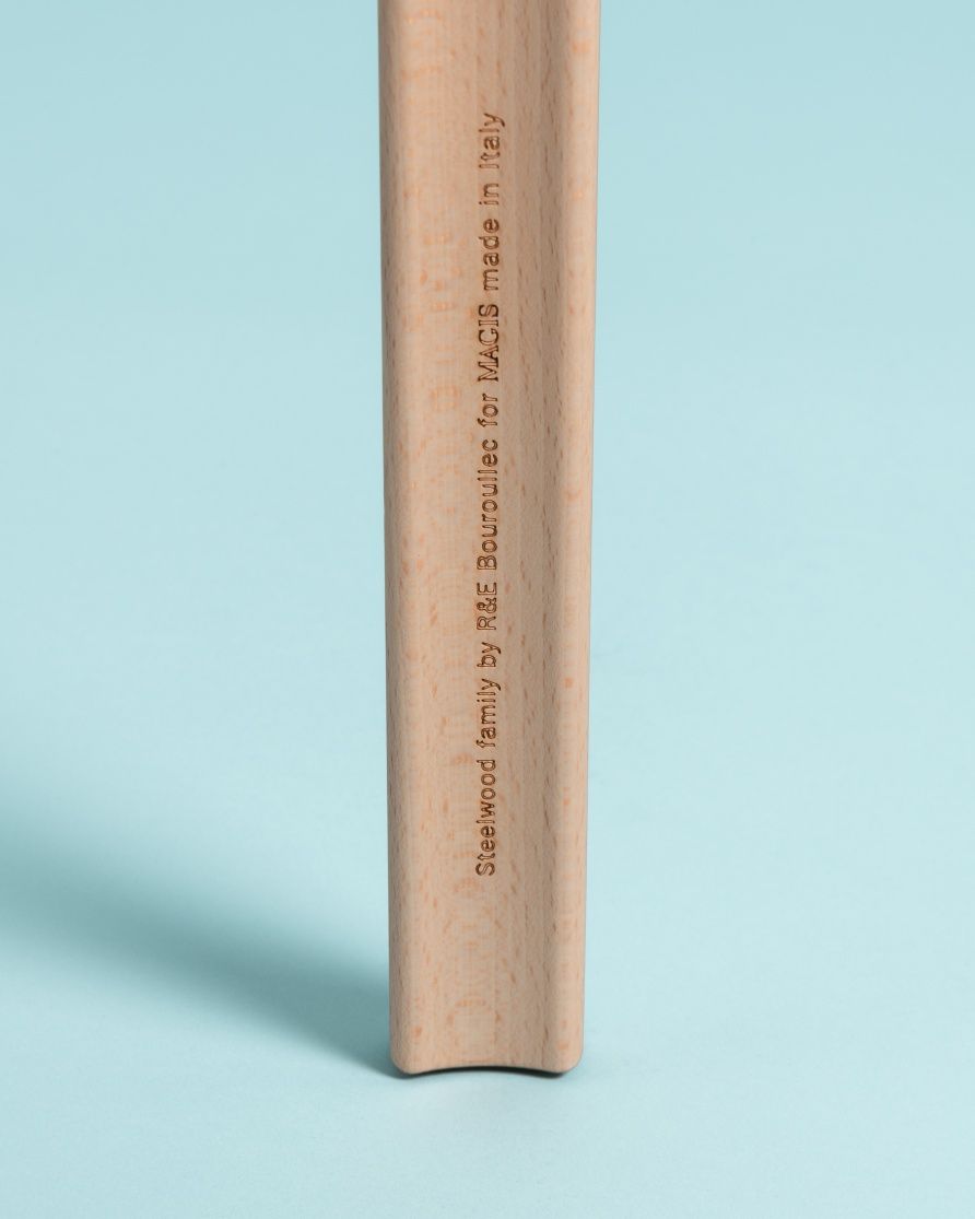 Detailaufnahme eines Holzfußes des Steelwood Coat Stand Garderobenständers von Magis mit eingraviertem Schriftzug.