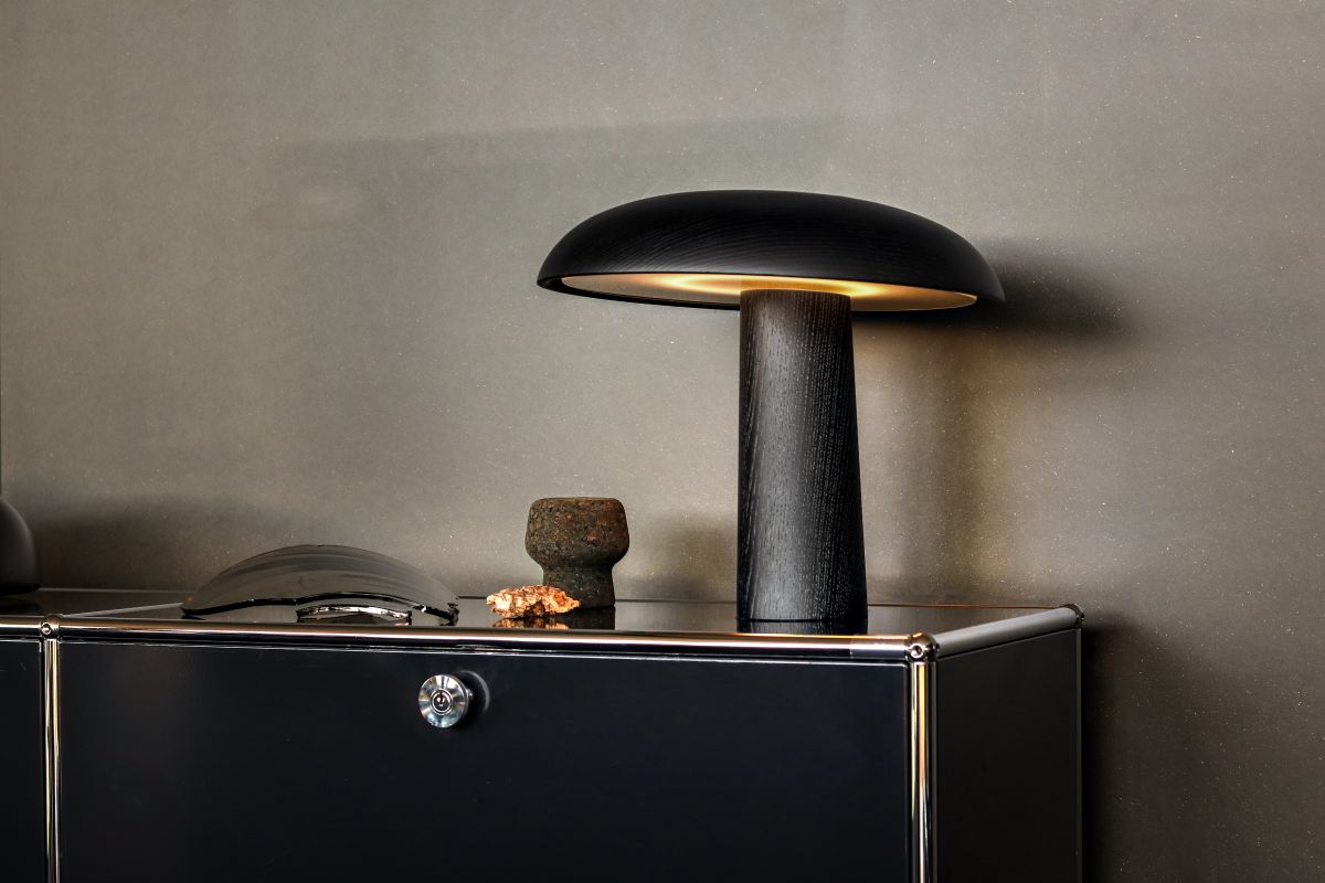 Forma Tischleuchte von ClassiCon, moderne Pilz-Tischlampe aus Holz in Schwarz auf einem Sideboard.