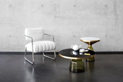 Bell Table Tisch von Classicon mit Marmorplatte und Glasfuß neben Sessel.